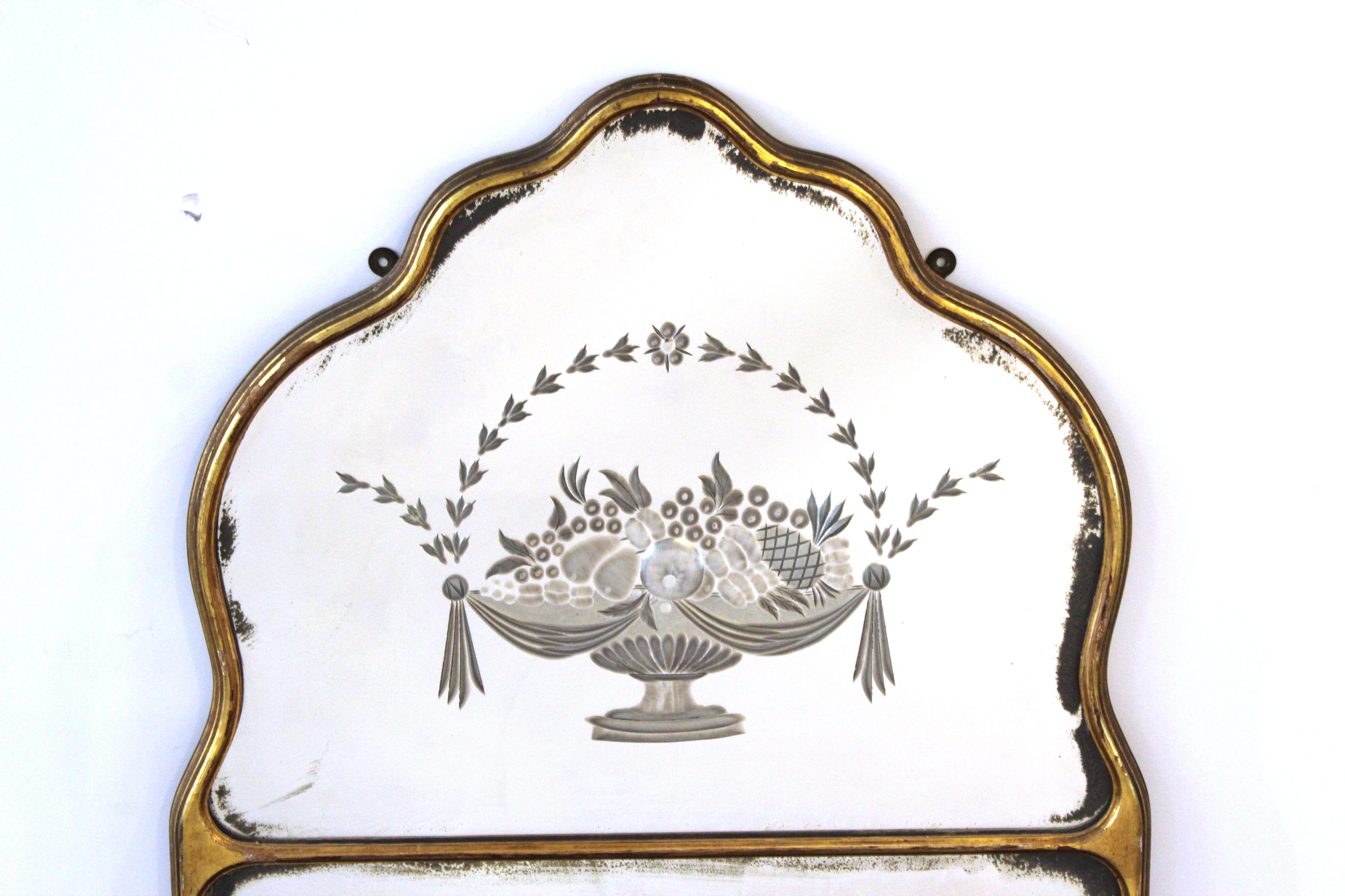 Art Deco wall mirror with gilt frame and etched decorative fruit basket in the upper section. The piece is in great vintage condition with age-appropriate wear.