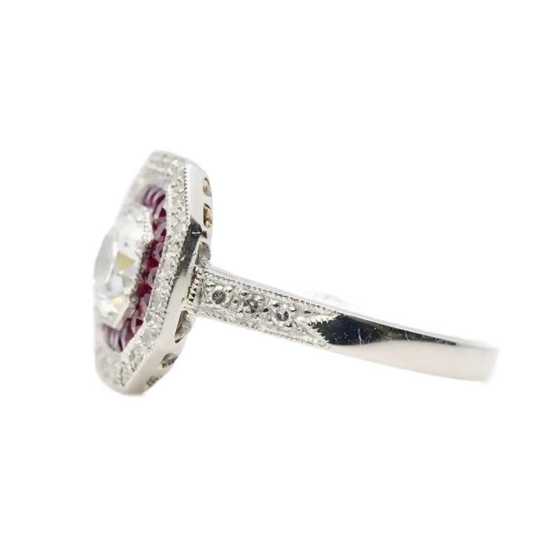 An Art Deco style French cut ruby, and European cut diamond double halo ring in platinum.

Centered by a 0.85 carat old European cut diamond of H color with VS2 clarity.

Framed by halos of French cut rubies, and pave set round diamonds.

The