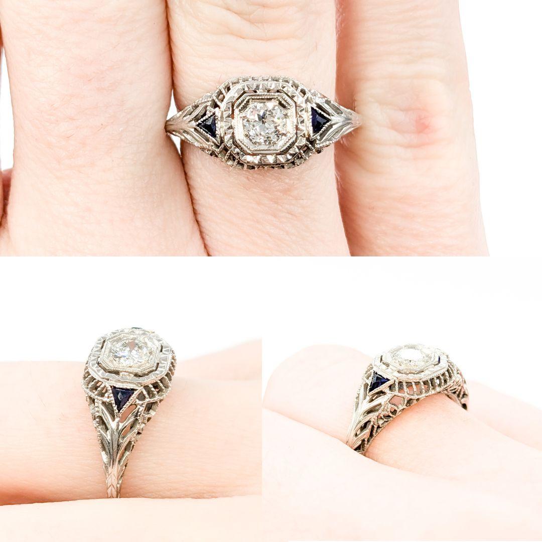 Art Deco European Cut Diamond & Sapphire Ring in White Gold

Introducing this beautiful Antique Ring, crafted in 14kt white gold. The ring features a .22ct Old European cut diamond centerpiece, complemented by striking synthetic sapphires. The