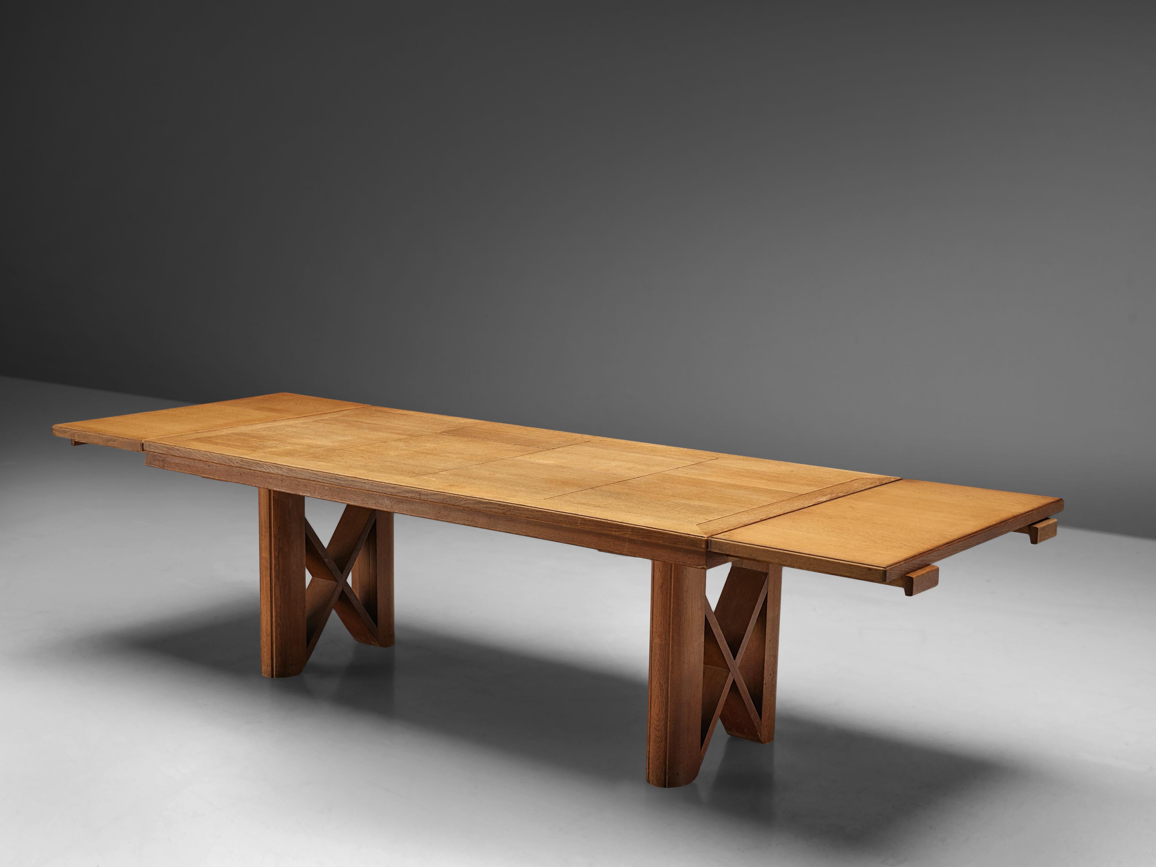 Dining table, in oak, by Guillerme et Chambron, France 1965. 

This oak extendable dining table is designed by French designer duo Jacques Chambron and Robert Guillerme. The legs of the table are stout and rigid and have a cross section for extra