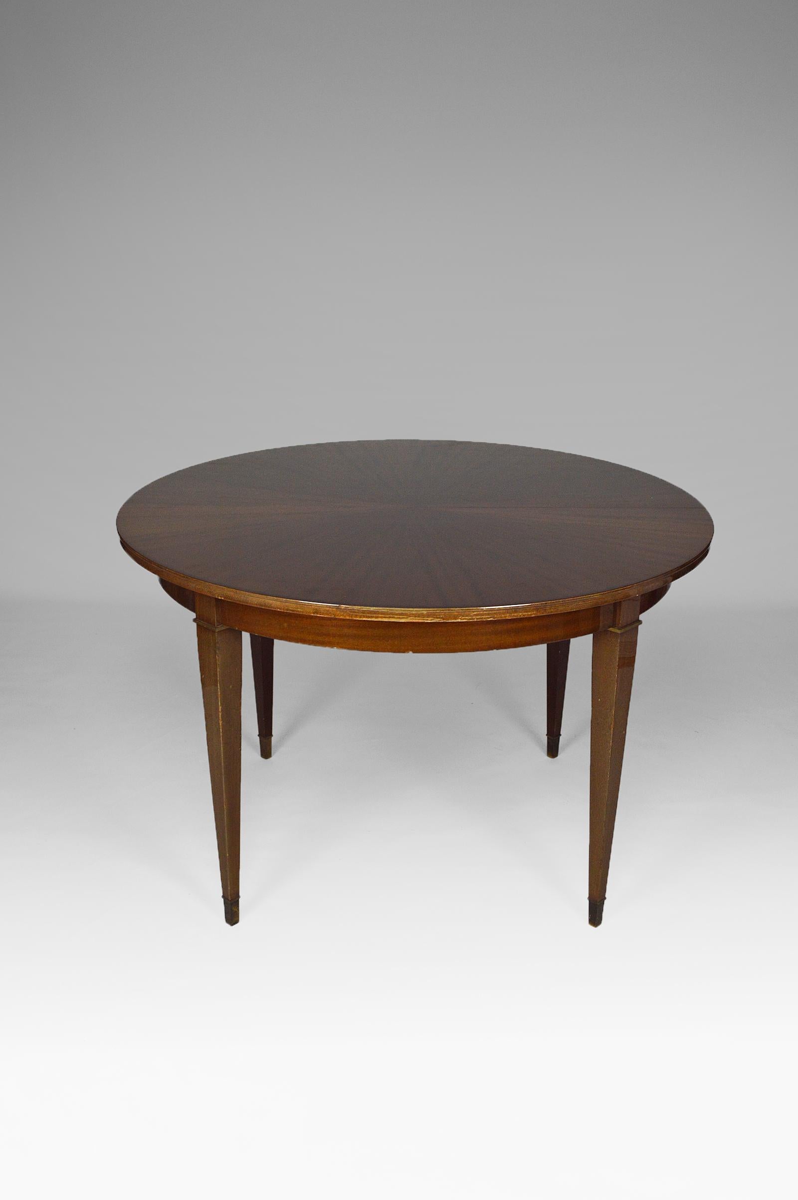 Beautiful round dining table with extensions, in solid and veneered mahogany. 

The table top is in veneered mahogany with a 