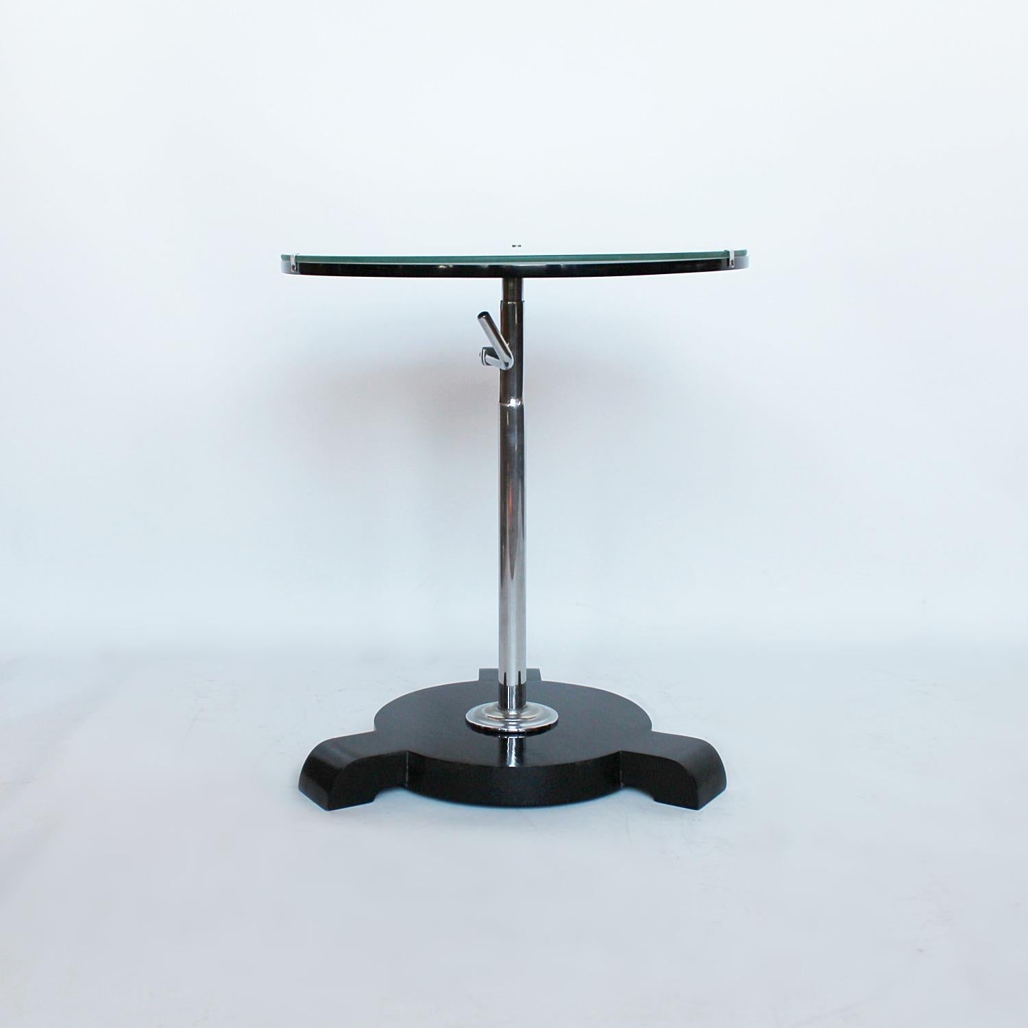 An Art Deco side table in painted wood and chromed metal, set over an extendable stem and three footed base.

   
