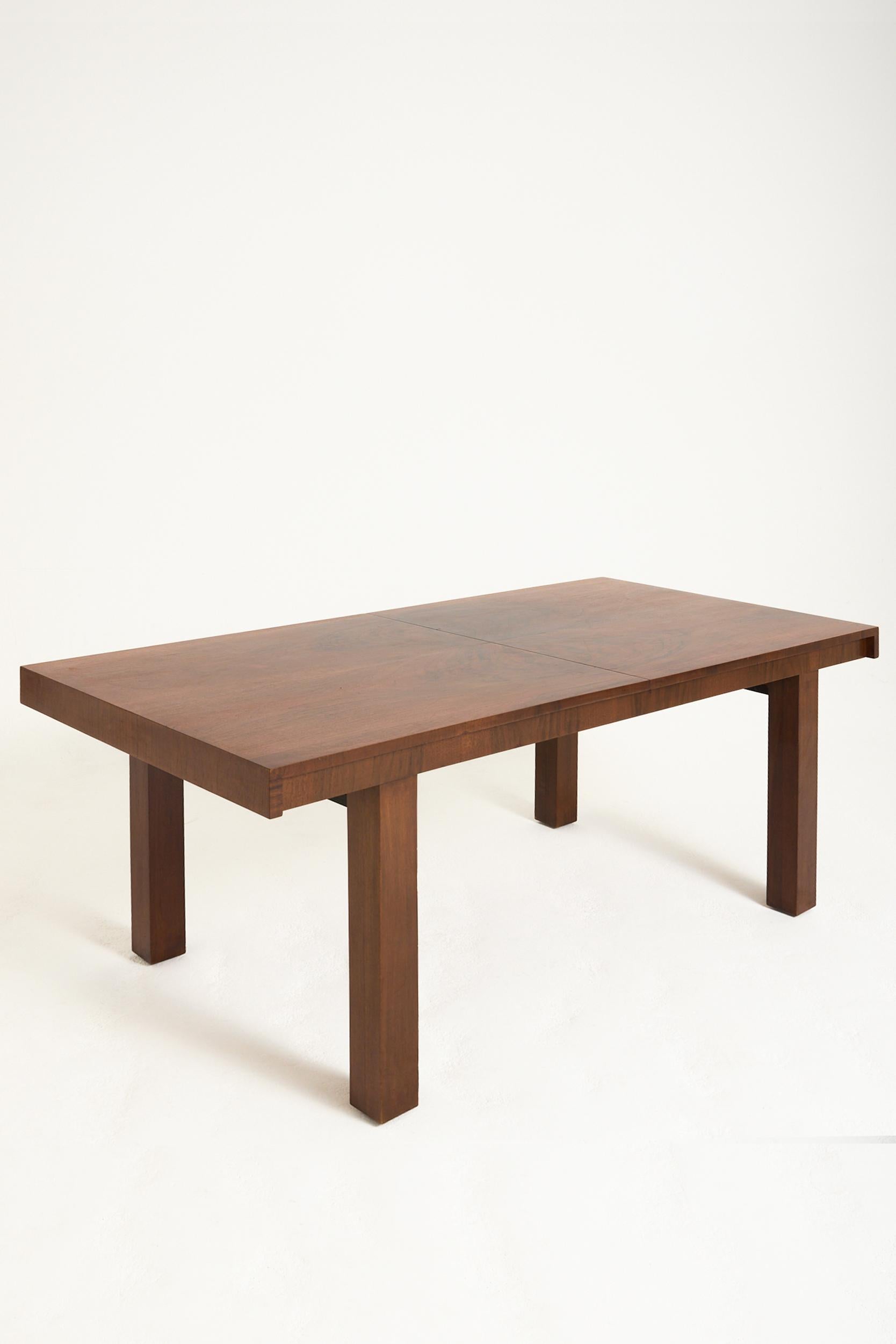 An Art Deco walnut dining table, with its extension system
France, Circa 1930
74 cm high by 168 cm wide by 85 cm depth 
With extension leaf: 229.5 cm wide by 85 cm depth