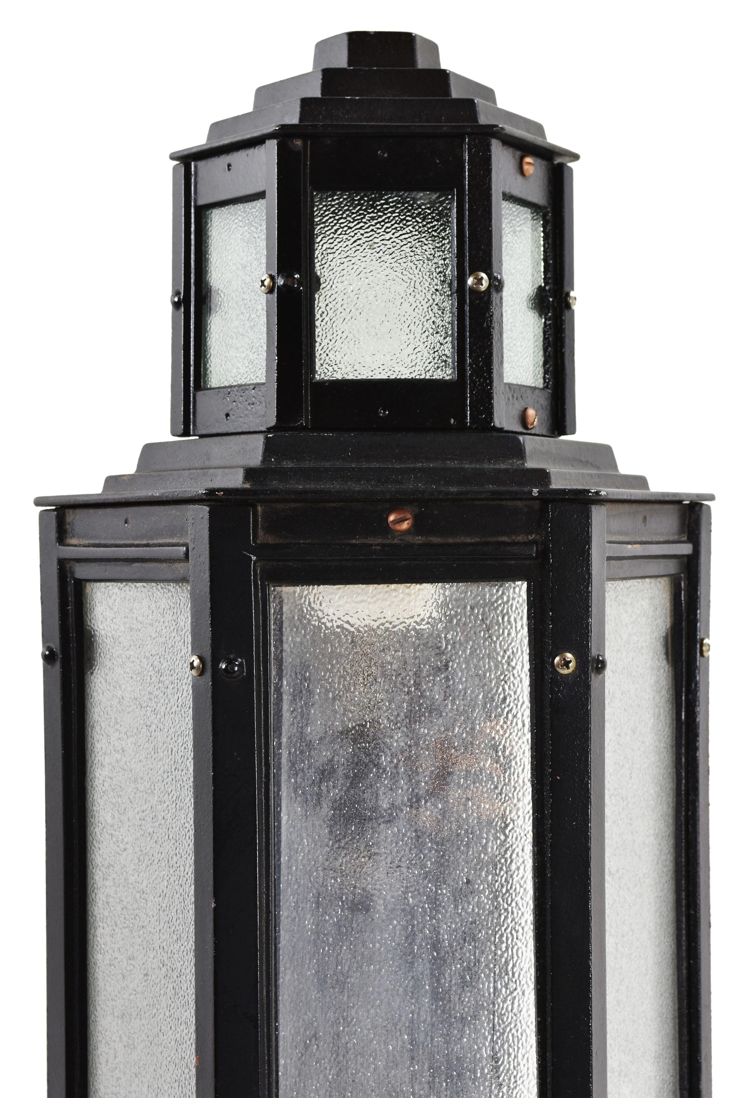 This impressive cast iron Art Deco exterior sconce features sharp hexagonal shapes and textured glass. Unique geometric designs highlight the stepped backplate of this skyscraper style piece, 

2 Available
circa 1920s
Condition: Excellent
Finish: