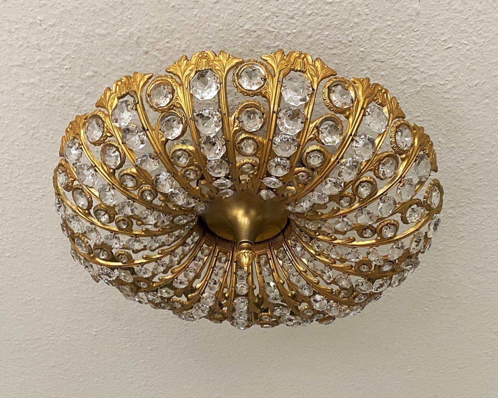 A beautiful, large Art Deco faceted crystal and cast gilt bronze flush mount, Austria, 1950s. With five light sockets providing a bright, warm light from the ceiling. This wonderful piece is in excellent vintage condition, complete, the crystals