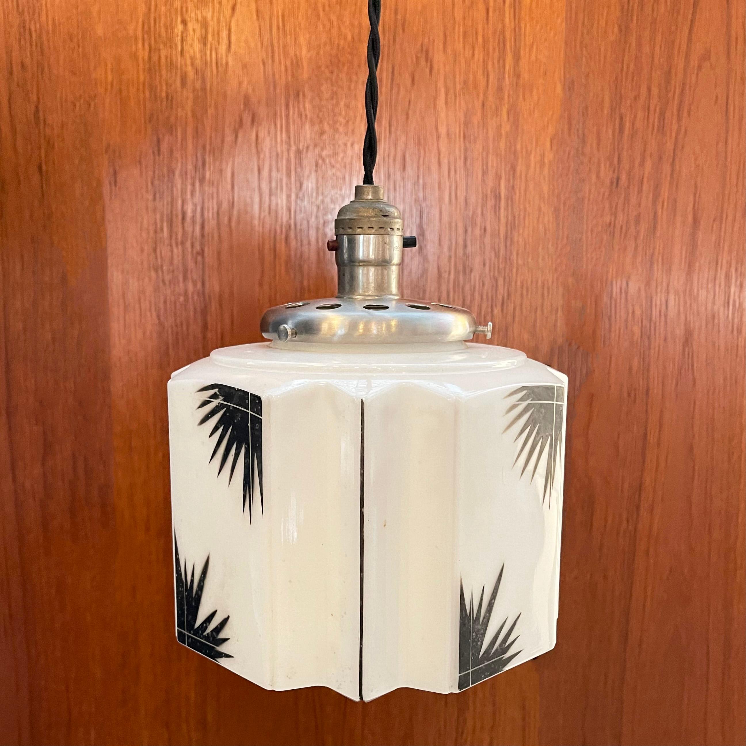 Cette lampe suspendue Art déco est dotée d'un abat-jour en verre laiteux facetté avec un motif de feuilles sur une armature en nickel brossé. Elle est nouvellement câblée avec un cordon en tissu tressé de 40 pouces.