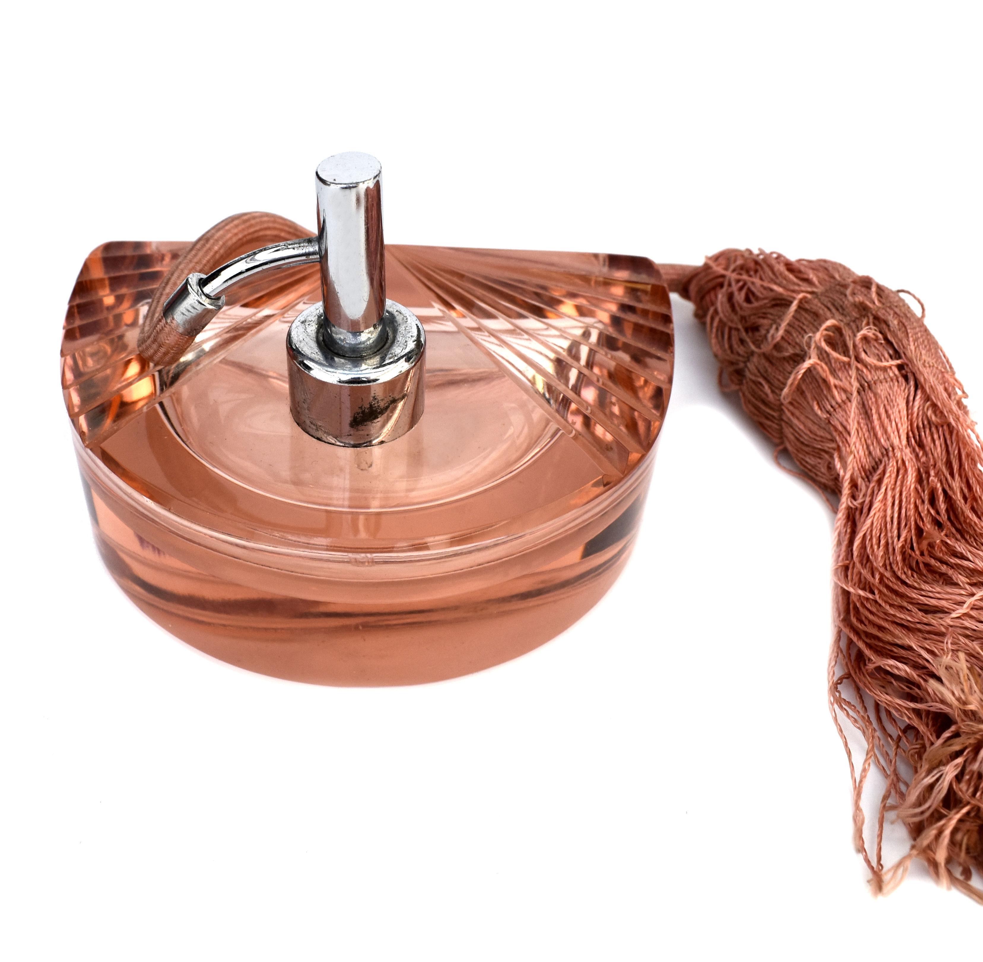 For your consideration is this beautiful and very unusual shaped Ladies perfume atomizer. Made from cut glass in a peachy pink tone, the body is cut to create a fan shape. The chrome sprayer has it's original silk tassel and bulb. This is a good