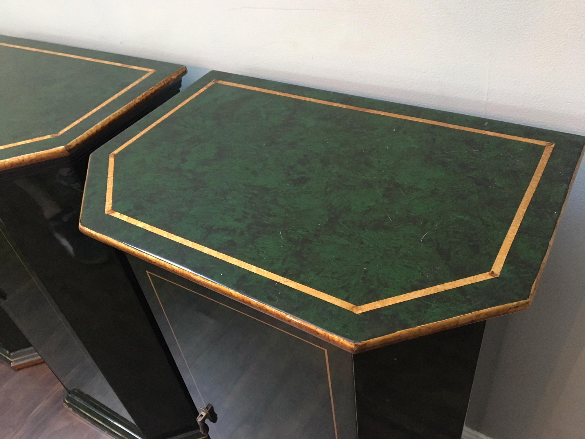 Set of three matching cabinets in faux-malachite with gold gilt trim in an art deco style. Also perfect for your Hollywood Regency decor. Each cabinet opens to reveal shelved storage space. Brass tassel hardware. Excellent vintage condition with a