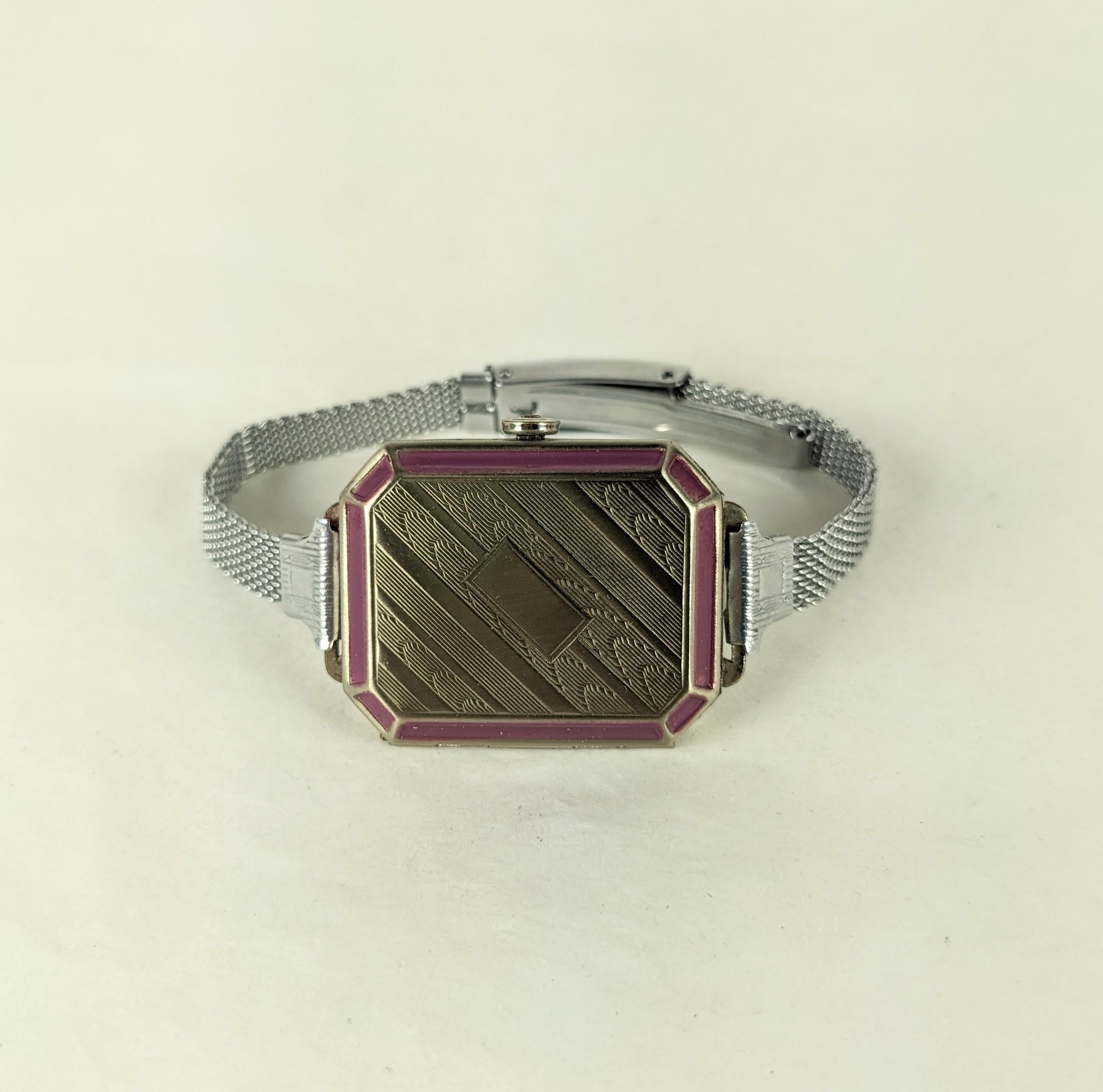 Art Deco Faux Watch Compact aus den 1920er Jahren. Sie sieht aus wie eine Uhr aus Chrom mit Emaille-Akzenten. Er lässt sich öffnen und gibt den Blick auf die beiden Fächer für Puder und Rouge frei. Gezeichnet 