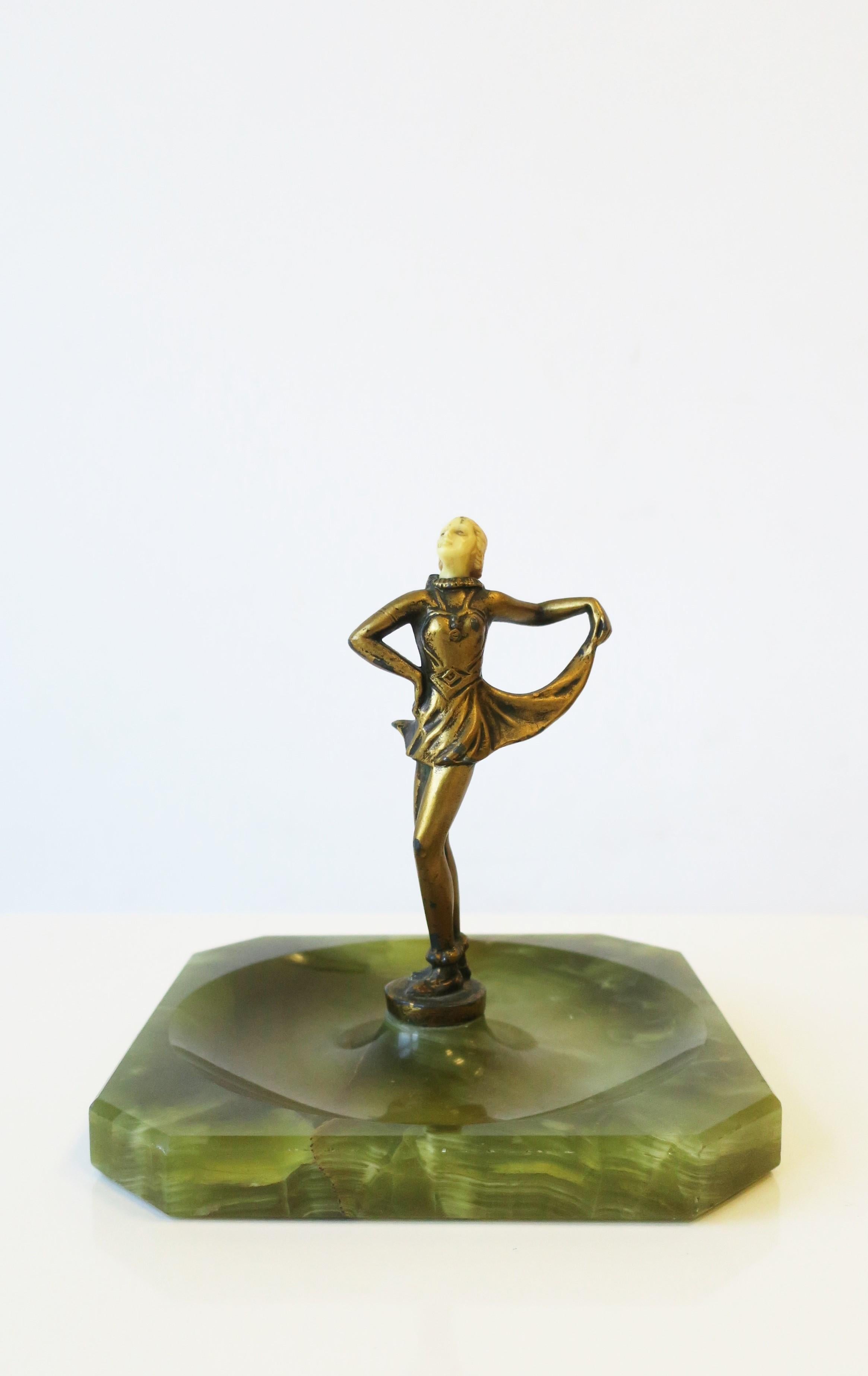 A brass female dancer sculpture and green onyx marble base vide-poche catchall, Art Deco period, circa early-20th century. Sculpture's head is resin and body with a gold overlay on brass, finished with a green onyx marble base. Great as a standalone