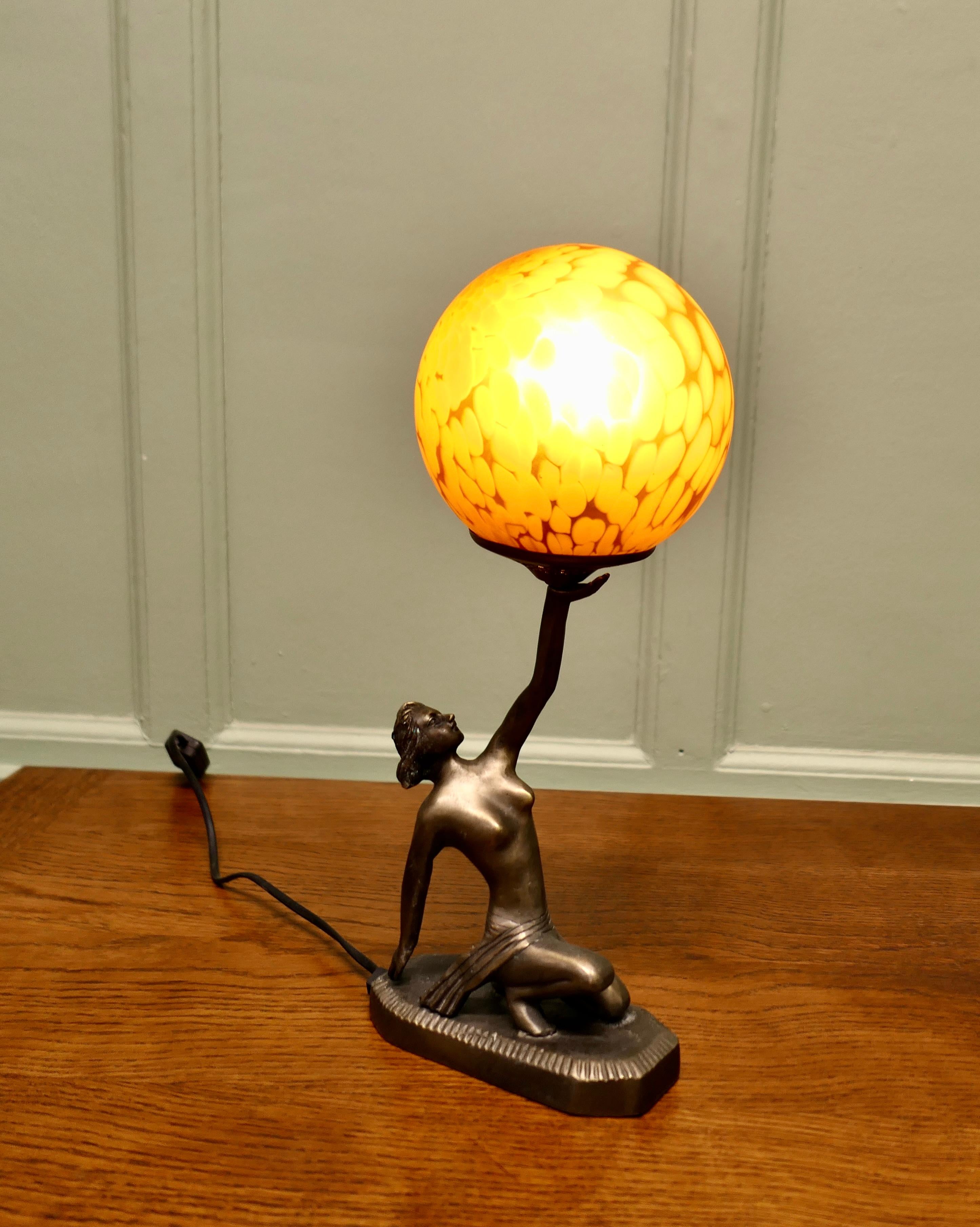 Lampe Globe Art Déco - Sculpture féminine en bronze

Cette charmante sculpture de dame n'est vêtue que de son pagne
est agenouillé sur un socle et tient en l'air un objet d'ambre et d'or.
globe de verre de fin de journée 
Notre dame est en bon état