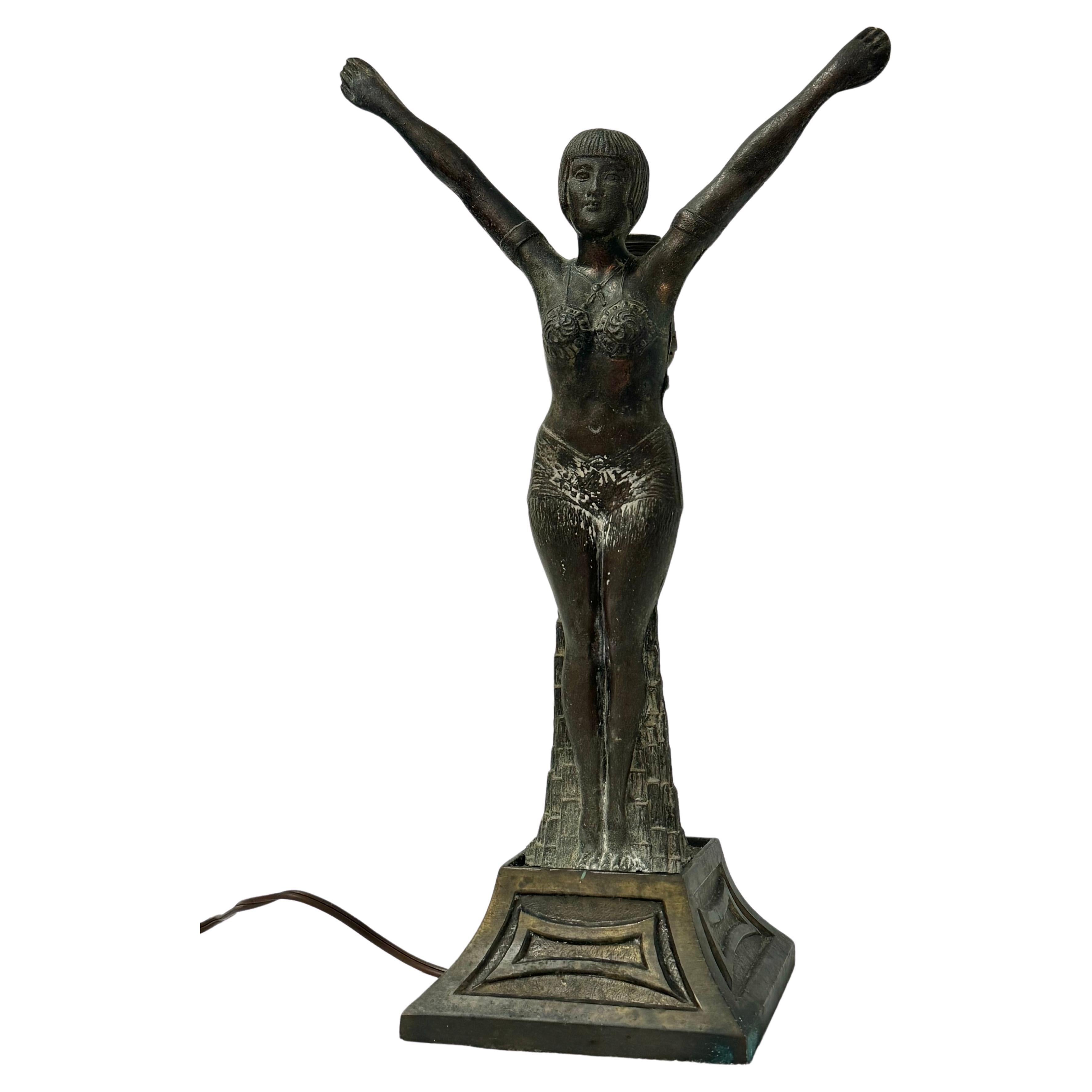 Lámpara Art Decó Bailarina.  Esta bailarina exótica está de pie con los brazos levantados por encima de la cabeza. .a bombilla está detrás de ella como un tocado.  Esta lámpara de tocador iluminará cualquier habitación con fabulosas vibraciones