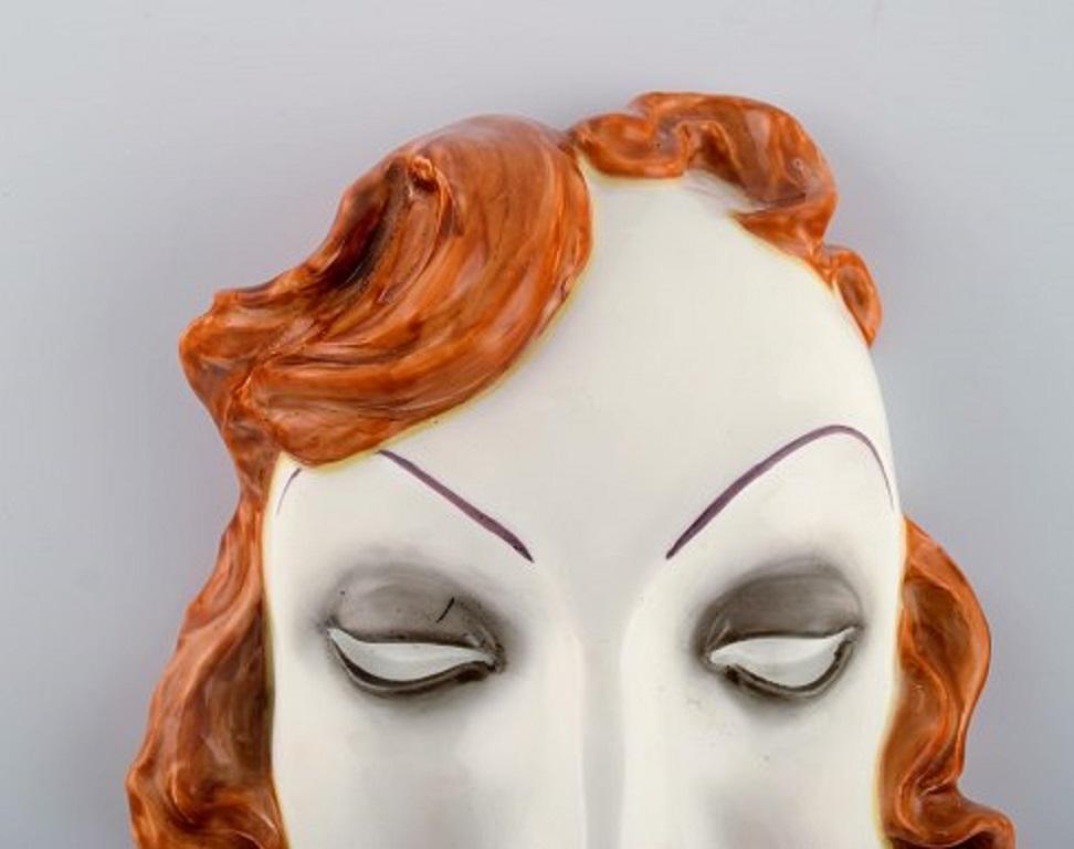 Art Deco female face in hand painted glazed ceramics, Germany, 1950s.
Measures: 18.5 x 13 cm.
In very good condition.
Stamped.