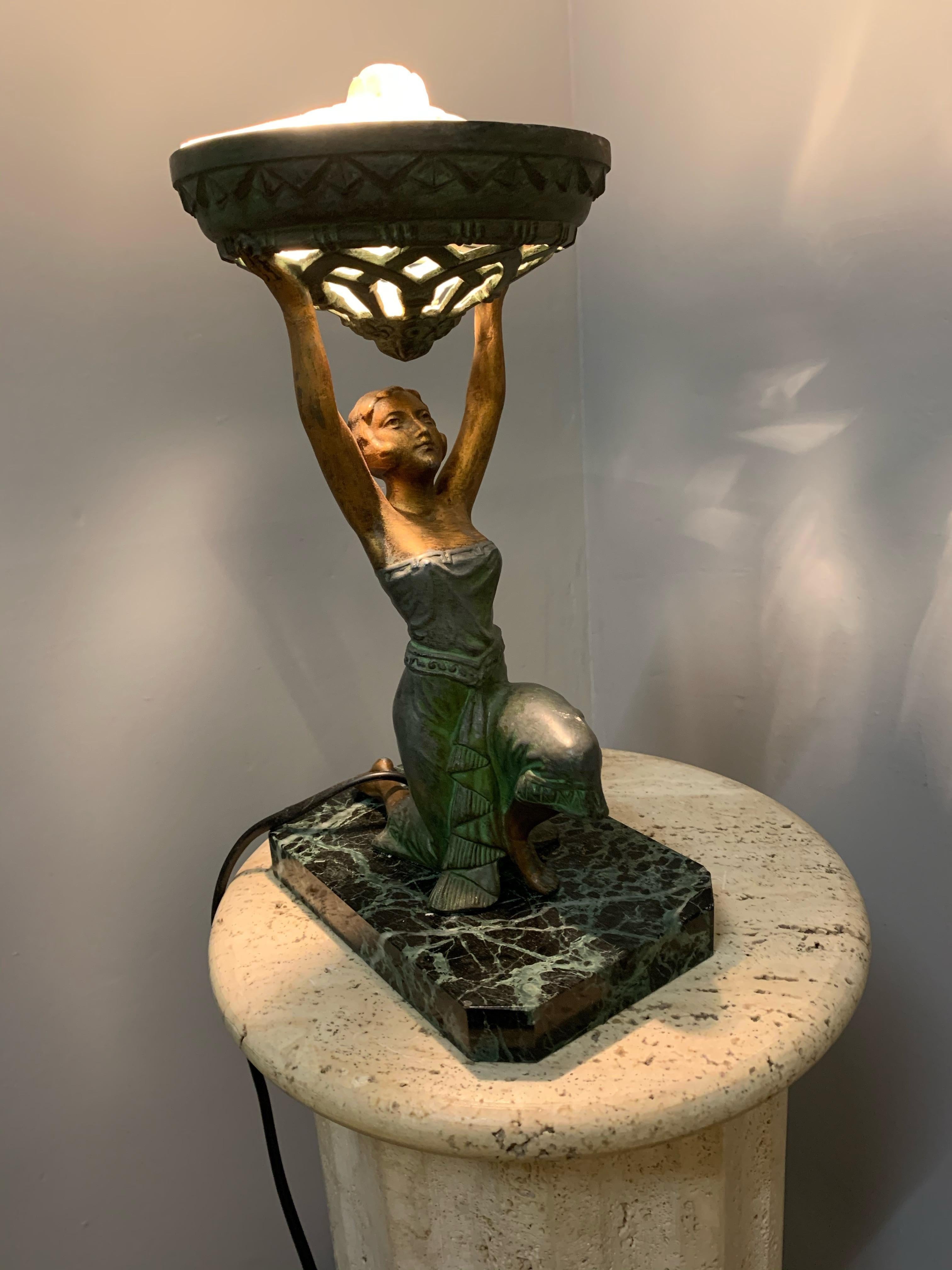 Egyptian revival Art Deco table lamp from circa 1925.

This beautifully patinated, sculptural lamp is still in wonderful condition. The metal female is dressed in the typical style of the roaring twenties. A period in which the global design