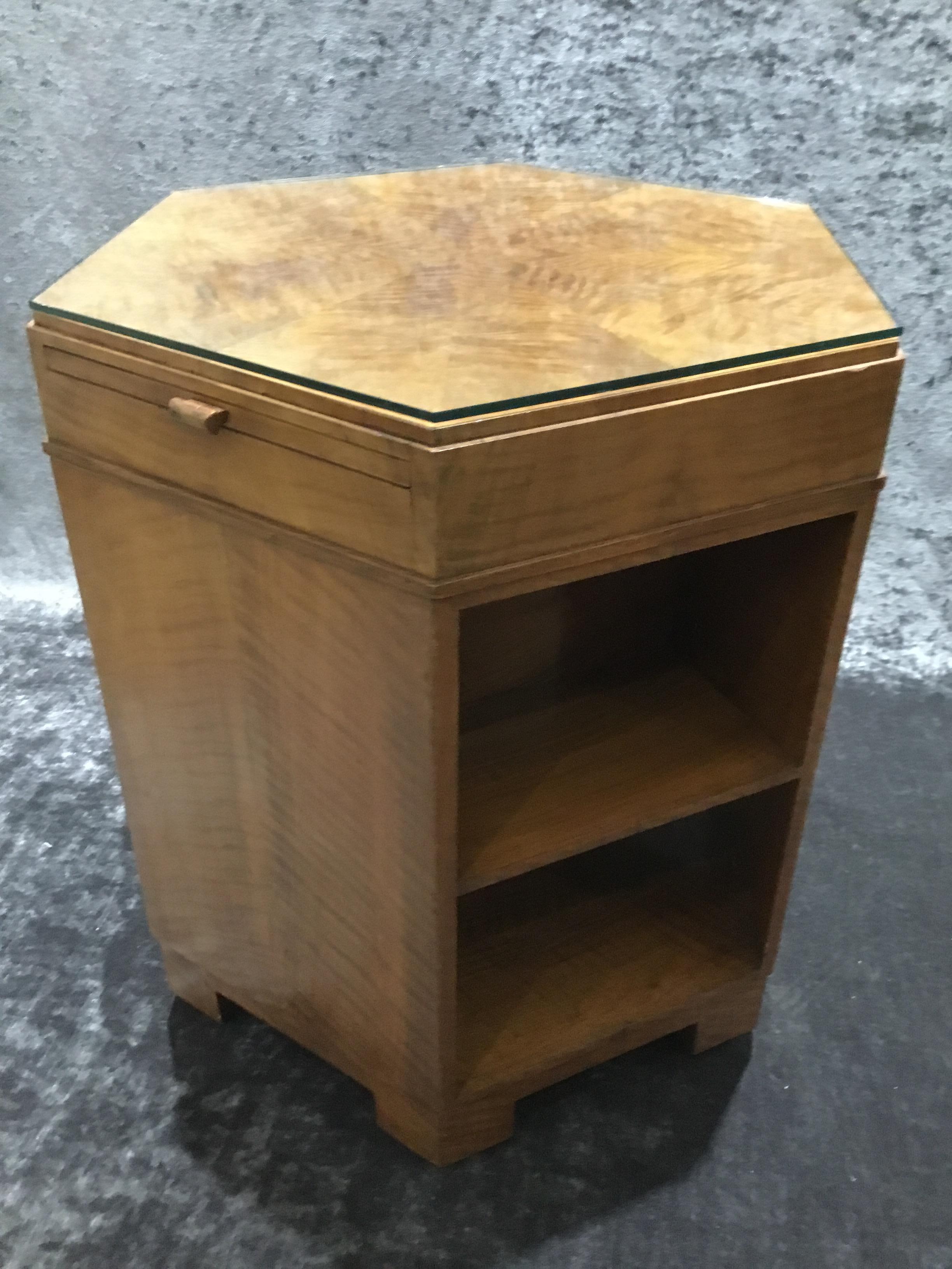 Art Deco hexagonal l side/library table in fiddleback maple with three contrasting bird’s-eye maple pull out drawers. The bottom shelf is open all the way through and the three middle shelves are compartmentalised for book storage.
Sits on six