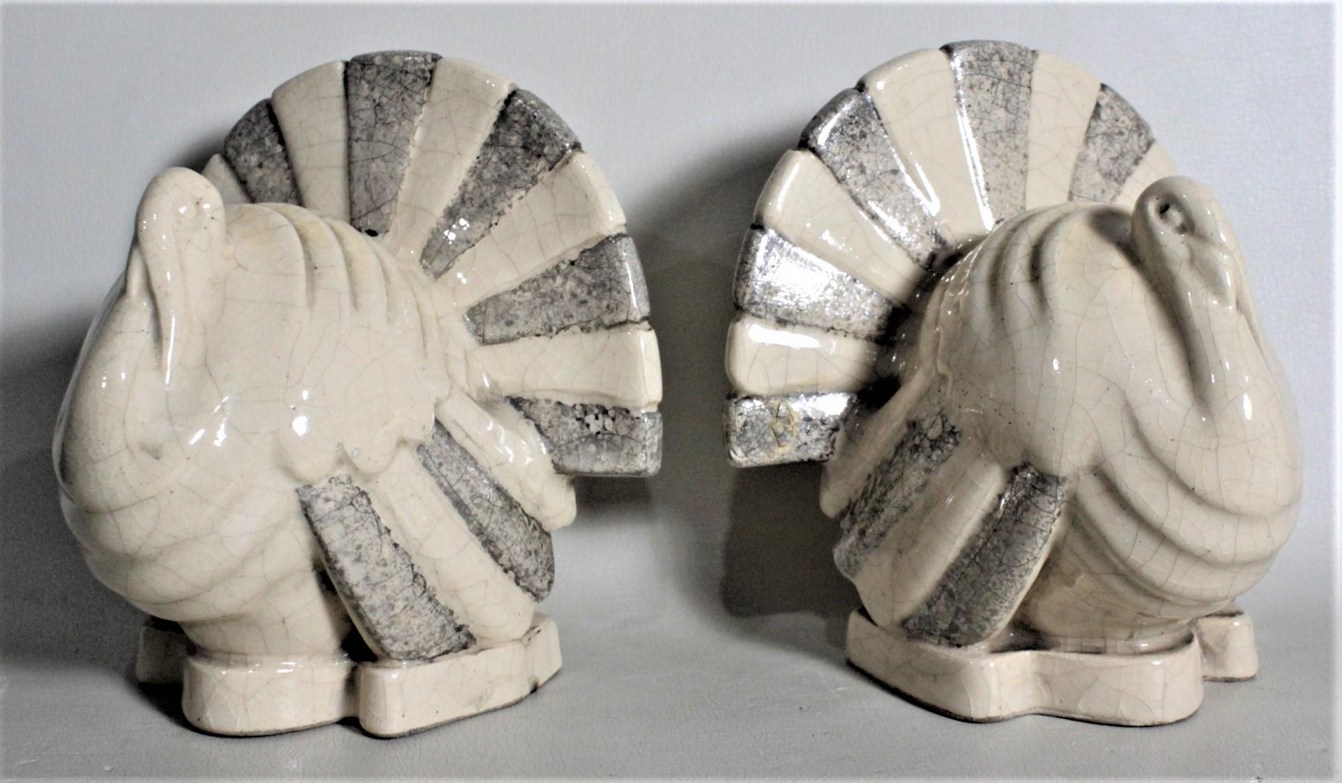 This pair of Art Deco ceramic bookends are signed, but the maker could not be identified, but presumed to have been made in France in approximately 1935 in the period Art Deco style. These ceramic bookends are a matched pair of 'Tom' turkeys done in