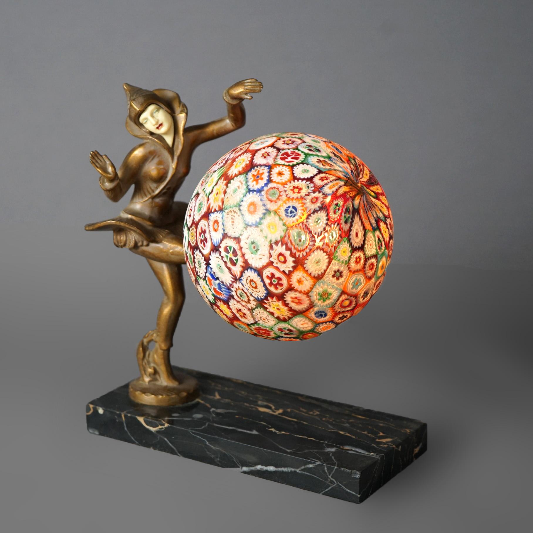 An antique Art Deco figural desk lamp offers base with cast metal sculpture of base a harlequin lady having celluloid face and playing with a millefiori glass ball form shade, c1930

Measures - 8.75