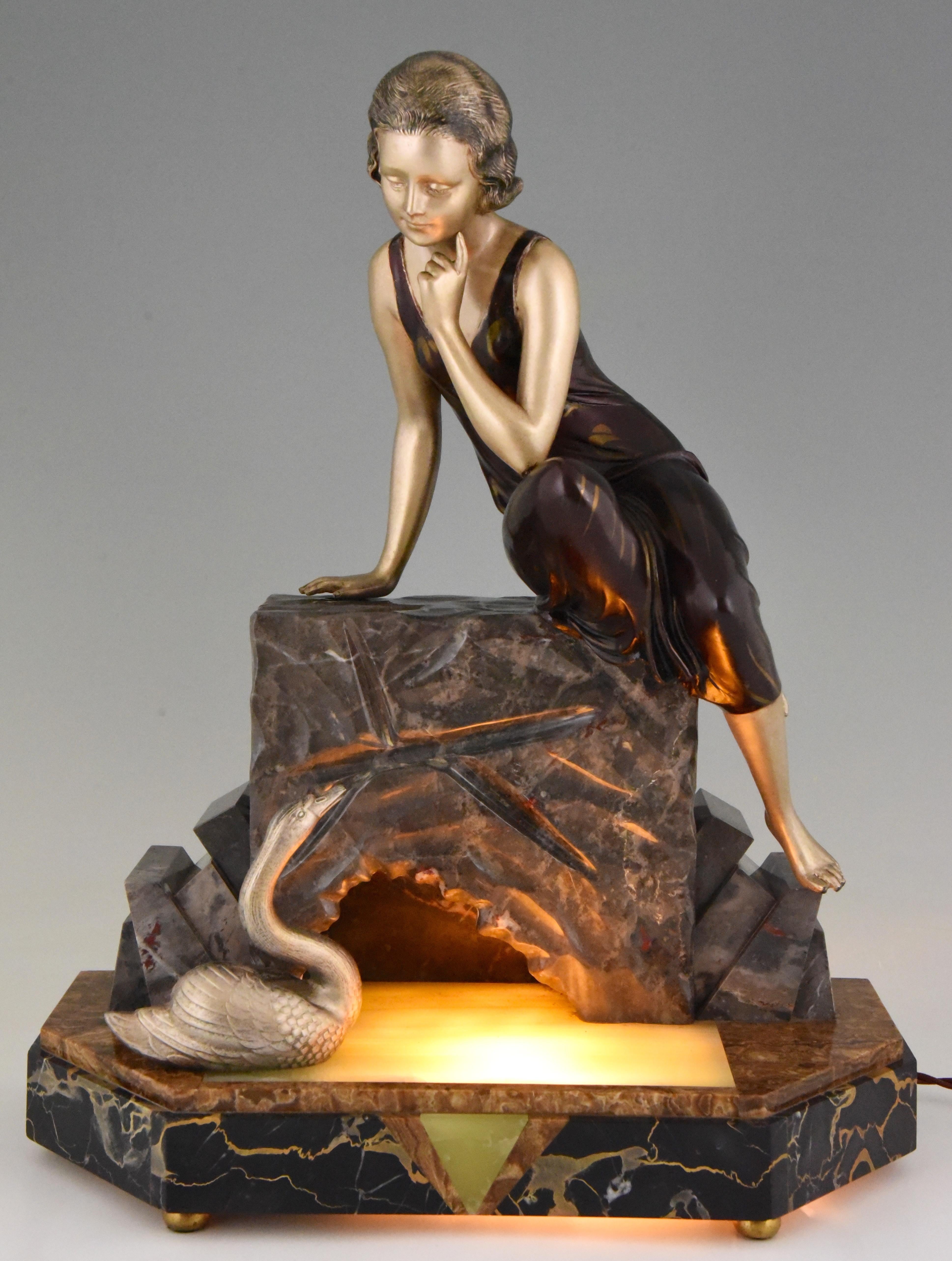 Lovely Art Deco figural lamp, lady sitting on a rock looking at a swan in the water. Signed by the French artist Uriano. Very nice patina, soft and warm ambient light, circa 1930.
 