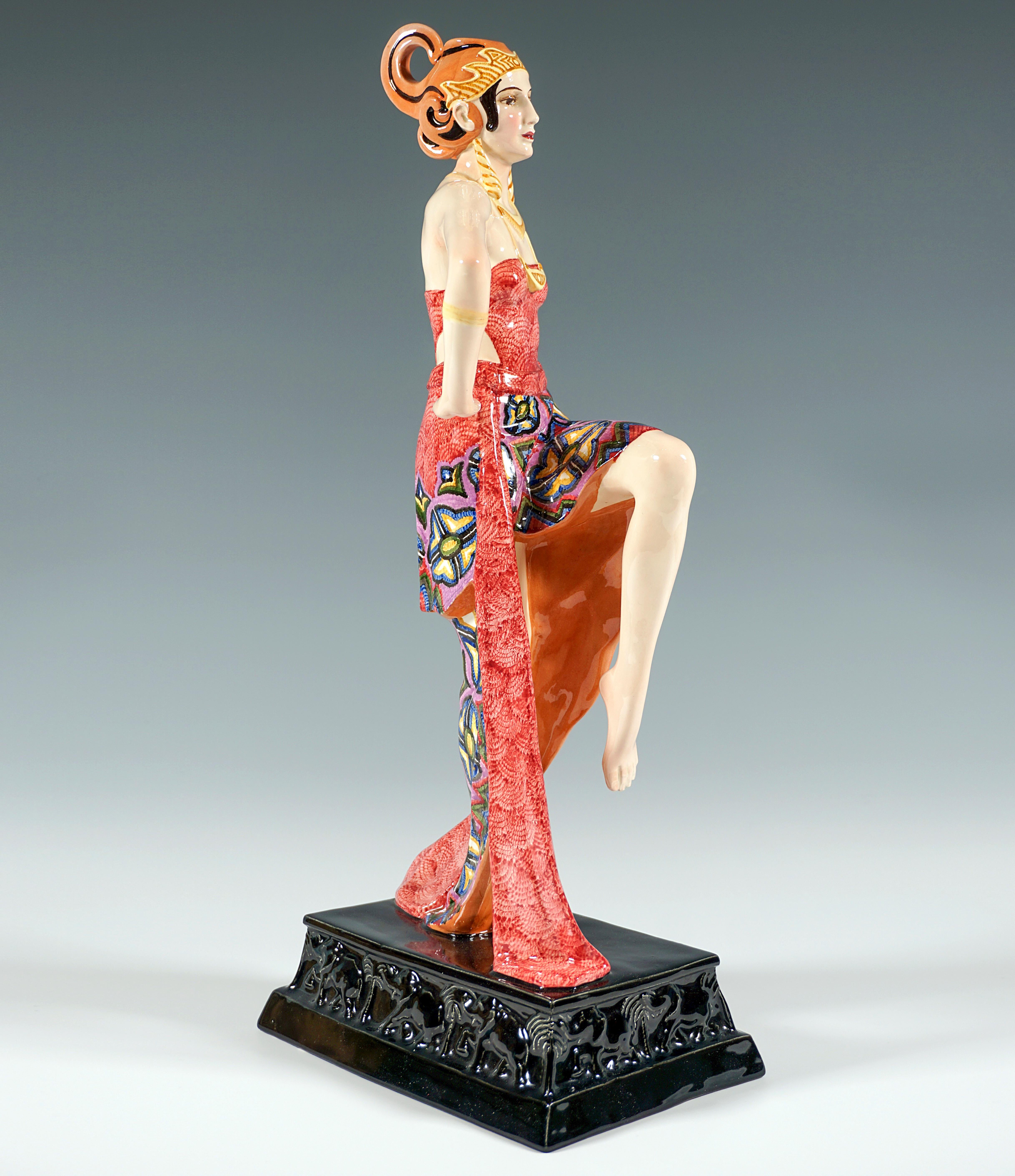 An exceptional model by the Goldscheider company, which has only rarely been produced:

A dancer posing upright, standing barefoot on one leg, wearing an elaborate, exotic headdress with a flame-like jagged tiara and a volute bent upwards at the