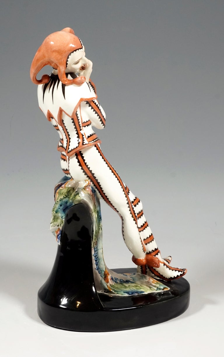 Very rare Art Deco Goldscheider ceramic figure of the 1920s.
Depiction of Till Eulenspiegel in a uniform costume with brown ribbons, framed by a black zigzag pattern, with matching shoes, a large ruff and a brown fool's cap, leaning on a pedestal
