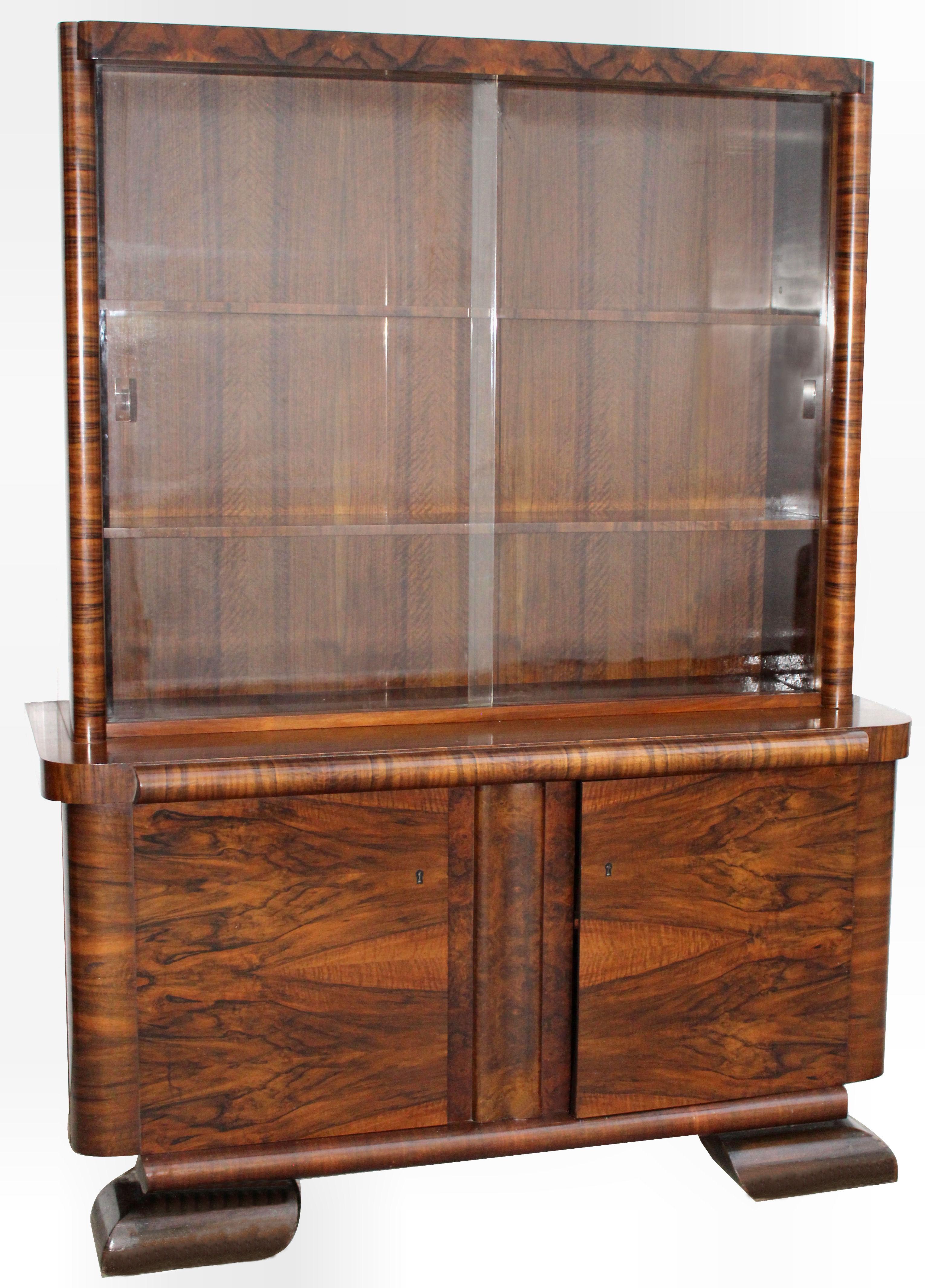 For your consideration is this very stylish 1930s Art Deco bookcase. Continental in origin, most likely German or Belgium. The two heavy glass sliding doors protect three generously sized shelves, offering plenty of space for either books or your