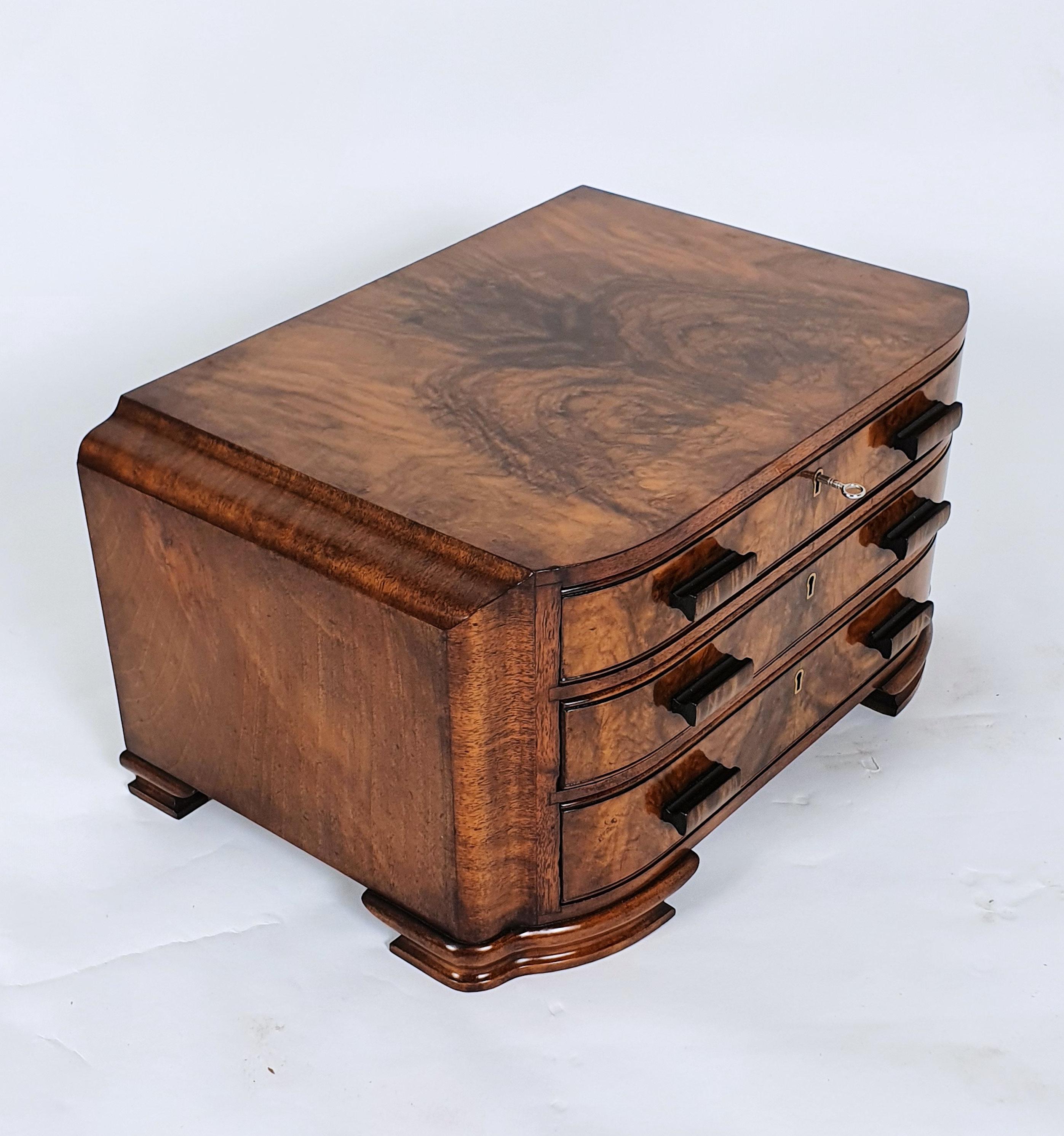 This beautiful Art Deco figured walnut bow fronted chest fitted with 3 drawers with a quantity of silver plated cutlery. The contents include 12 table knives,11 cheese knives,12 table forks,3 piece carving set,11 fish knives,12 fish forks,10