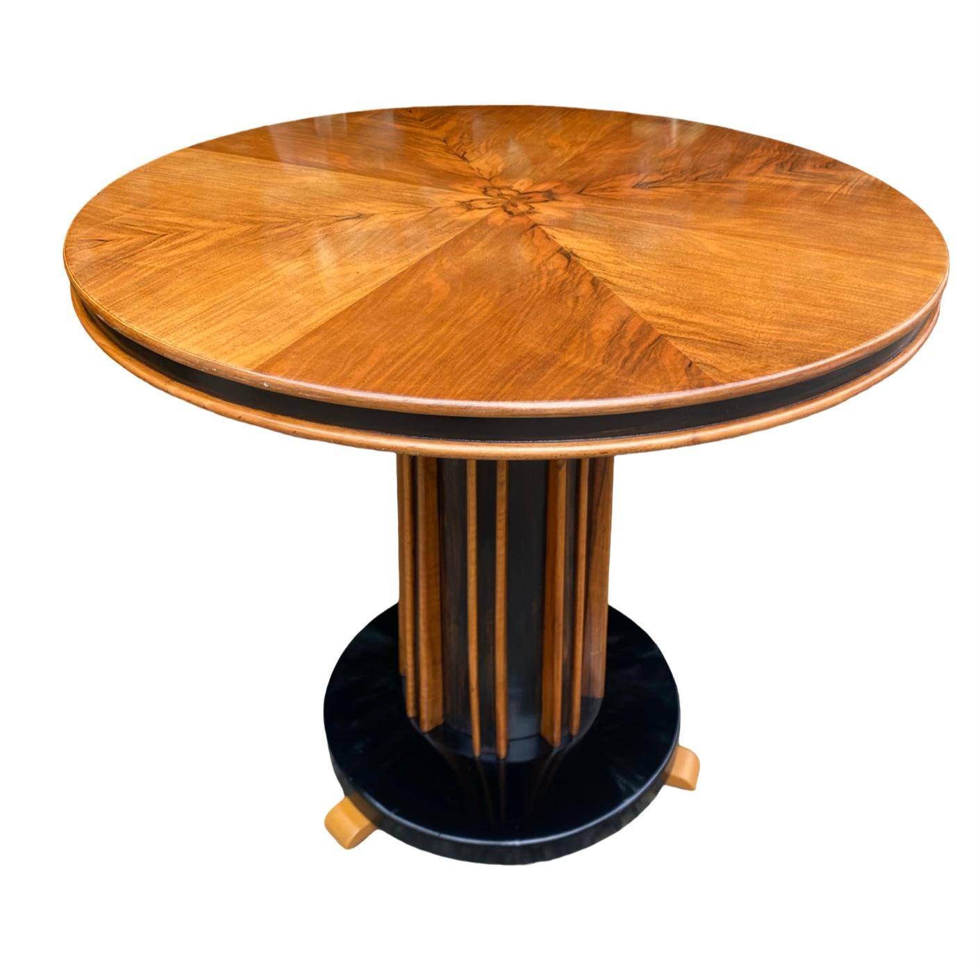 Ein wahrhaft atemberaubender Art Deco Couchtisch aus Nussbaumholz. Auf einem eindrucksvollen kannelierten Schaft aus Nussbaumholz und ebonisiert auf einem runden ebonisierten Sockel mit hübschen Nussbaumfüßen. Dies ist wirklich ein besonders