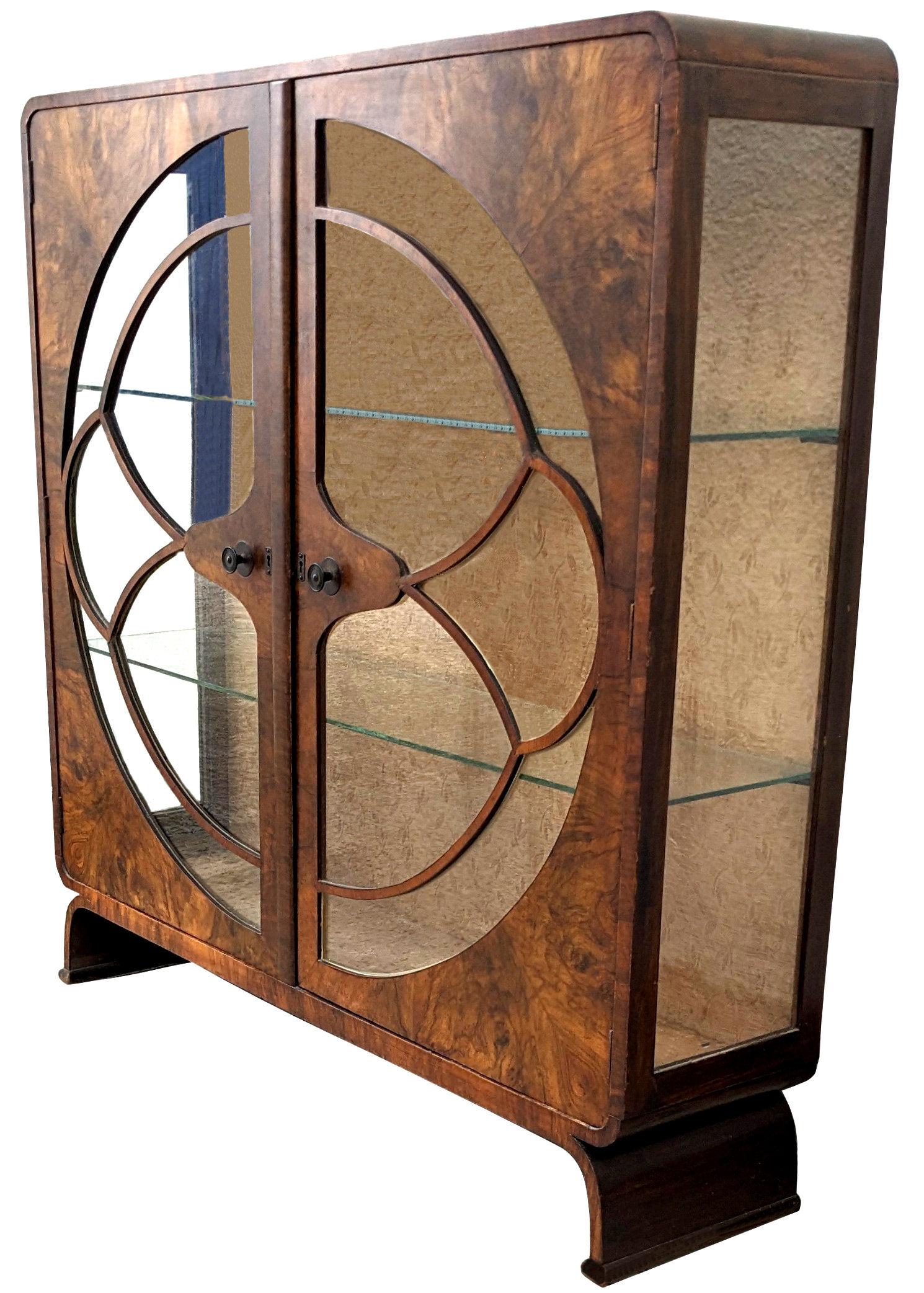 Original 1930s Art Deco display cabinet in an unusual shape. This lovely figured walnut veneered mid-tone cabinet features a generously sized interior display area for your 'collections'. The cabinet itself is a round shouldered square shape on half