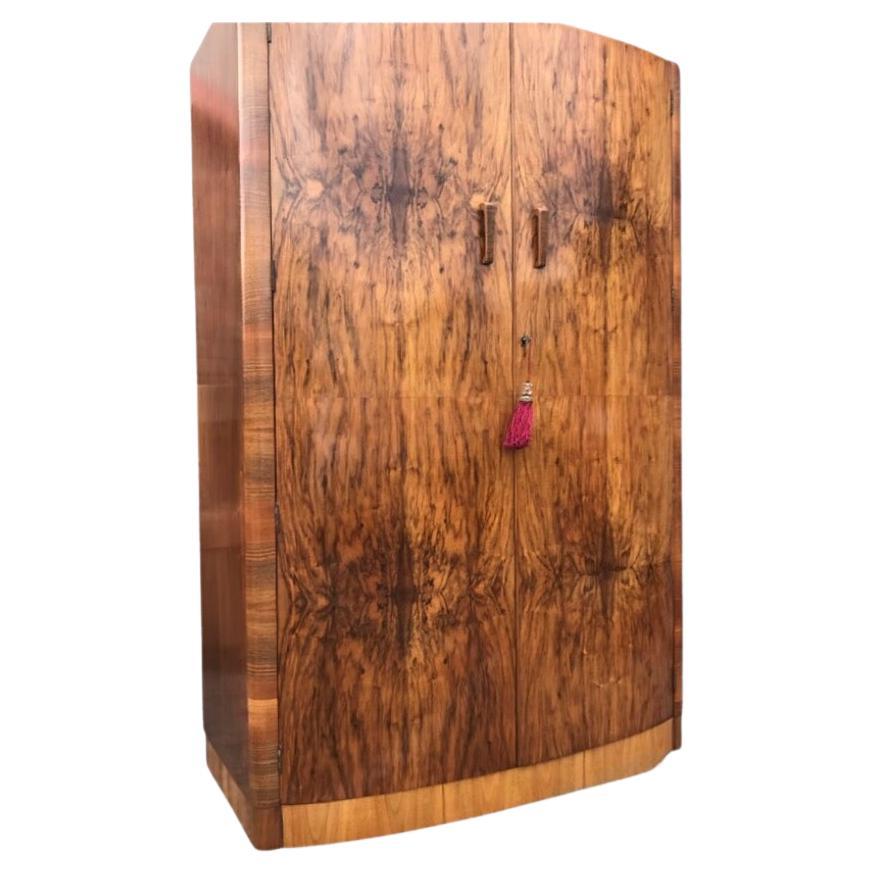 A beautiful  highly figured walnut Art Deco double wardrobe of bowfront design. This lovely capacious wardrobe has excellent hanging capacity, the doors open to reveal full hanging to the left and a shelved area to the right with hanging below. The