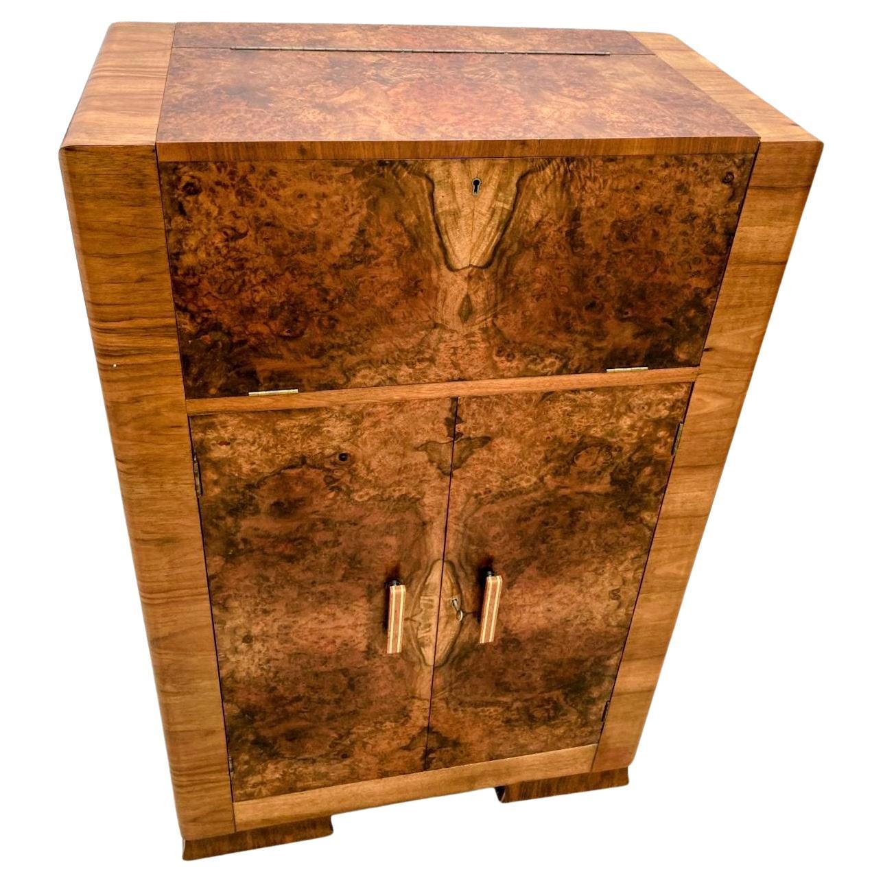 Wir bieten Ihnen diesen fabelhaften, stilvollen Art-Déco-Cocktailschrank aus den 1930er Jahren. Diese trockene Bar stammt aus den 1930er Jahren und hat alles, was man sich von einem Cocktailschrank wünscht. Der obere Innenraum hat einen