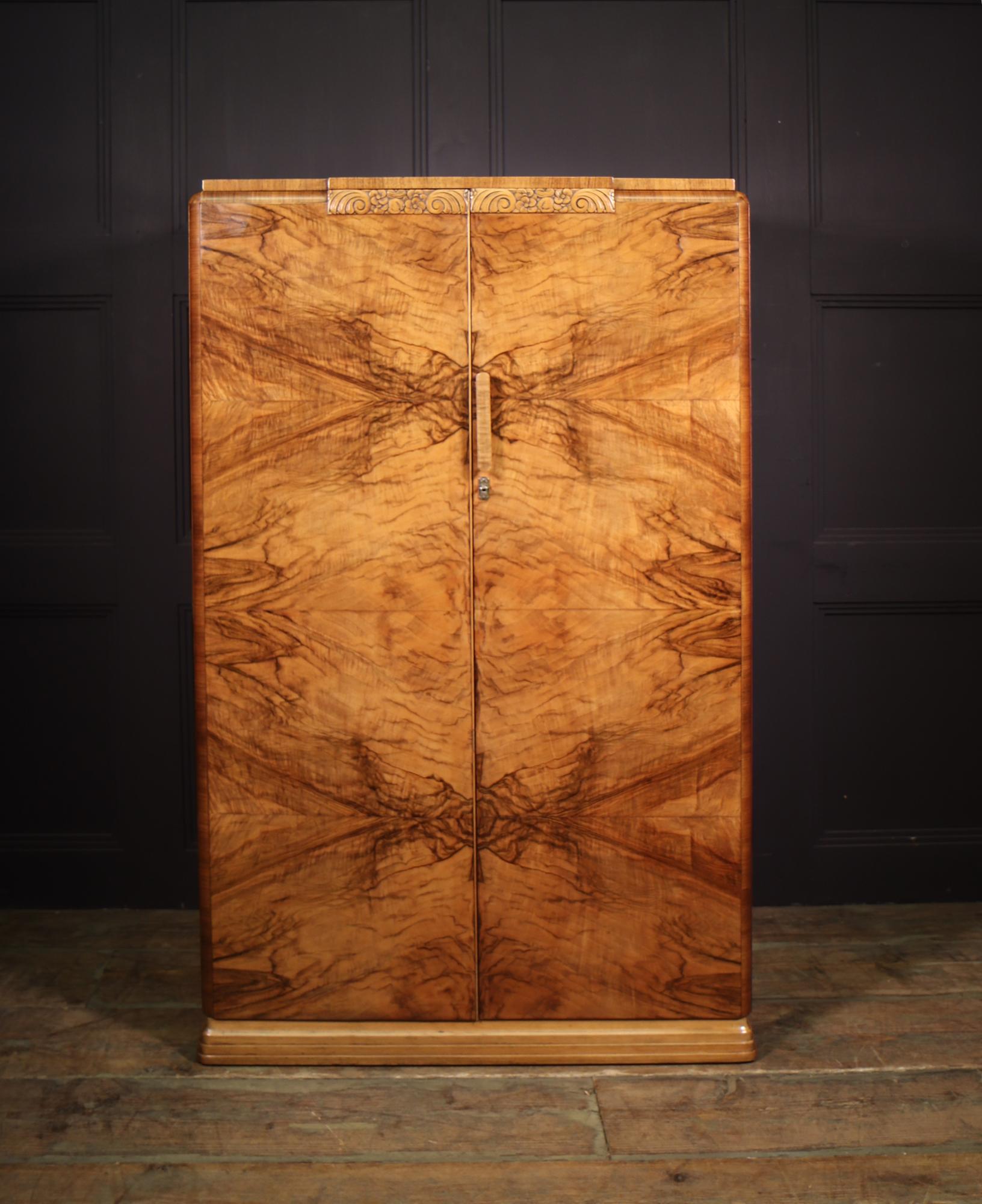 Produced in England in the 1930’s this figured walnut has two lockable doors with shelves behind, small carved panel to the top of the doors and stepped plinth this cupboard has been restored where necessary and fully polished by hand and in