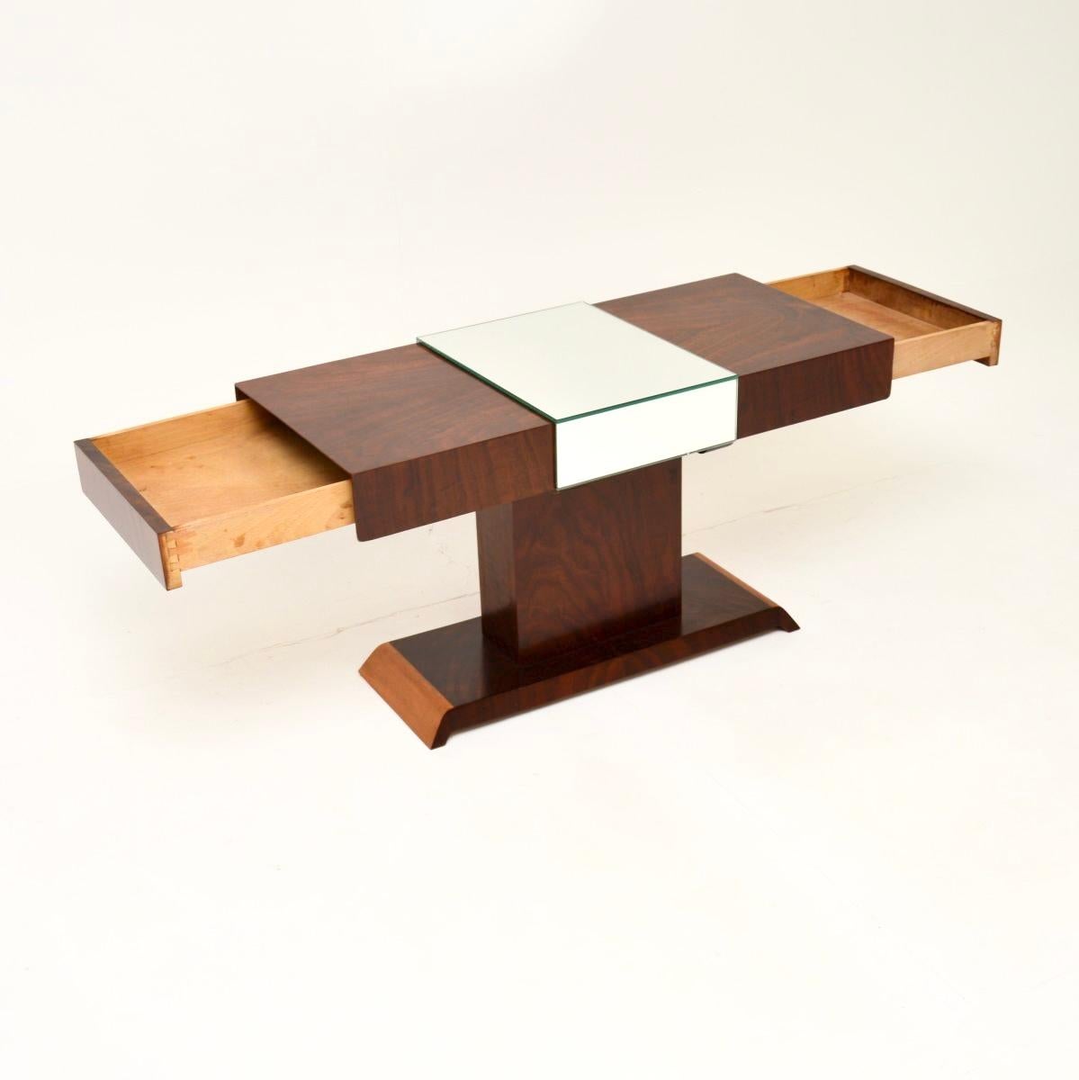 Table basse à miroir en noyer figuré de style Art Déco. Il a été fabriqué en Angleterre, il date des années 1930.

Il est d'une qualité exceptionnelle et présente un design agréable, avec un centre en miroir et des tiroirs qui s'ouvrent de chaque