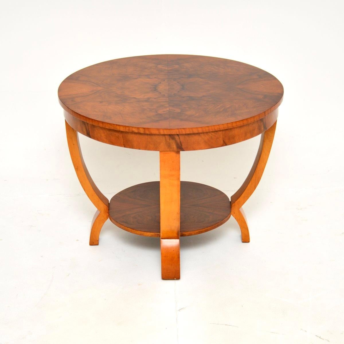 Une table d'appoint / table basse en noyer figuré de style Art Déco, élégante et de très bonne facture. Il a été fabriqué en Angleterre, il date des années 1930.

La qualité est excellente, le plateau circulaire et le plateau inférieur présentent de