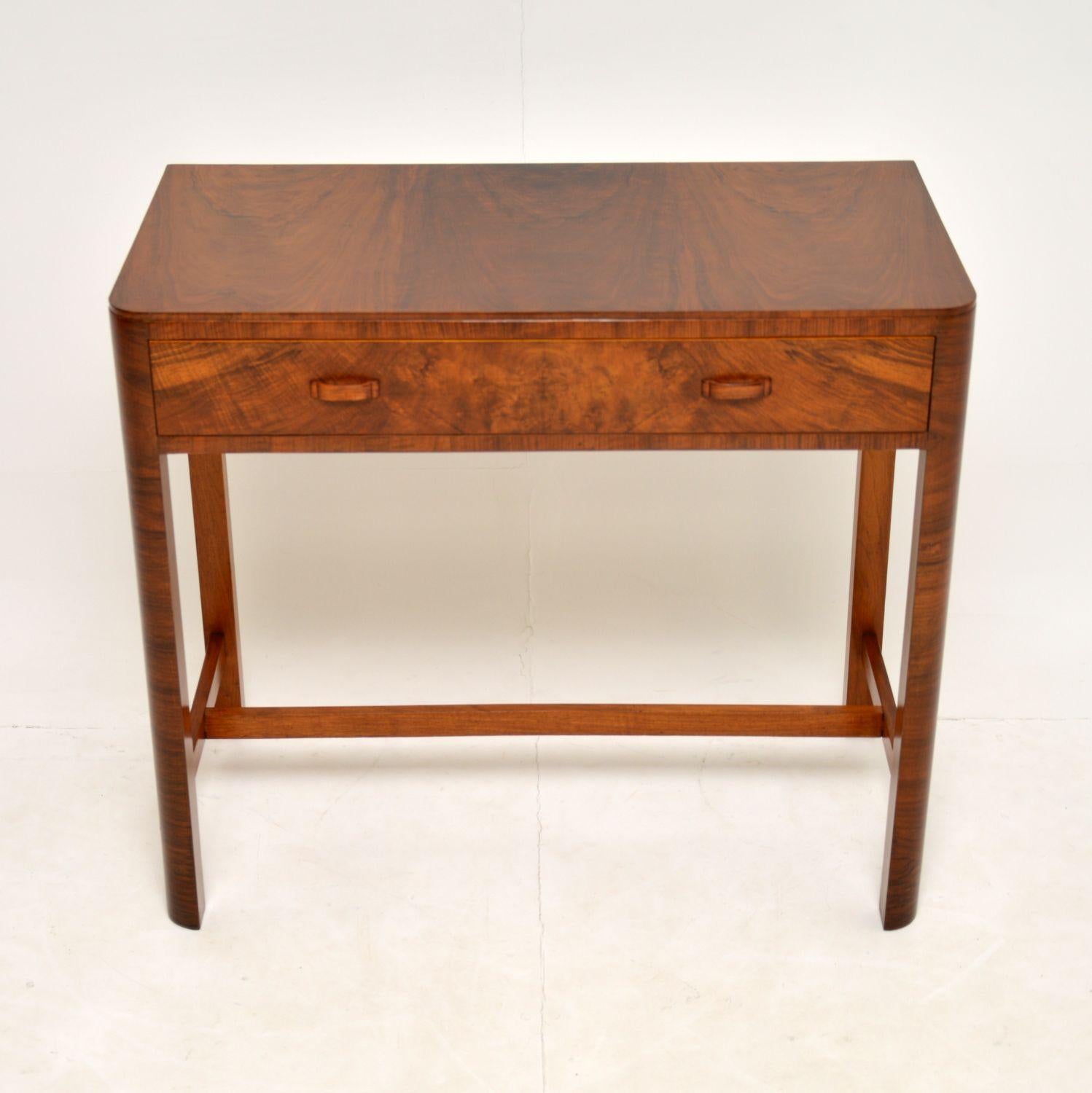 A beautiful original vintage Art Deco period side table in figured walnut. This was made and retailed by Heal’s in England, it dates from the 1930’s. The original Heal’s button can be seen in the drawer.

This is of amazing quality, it has