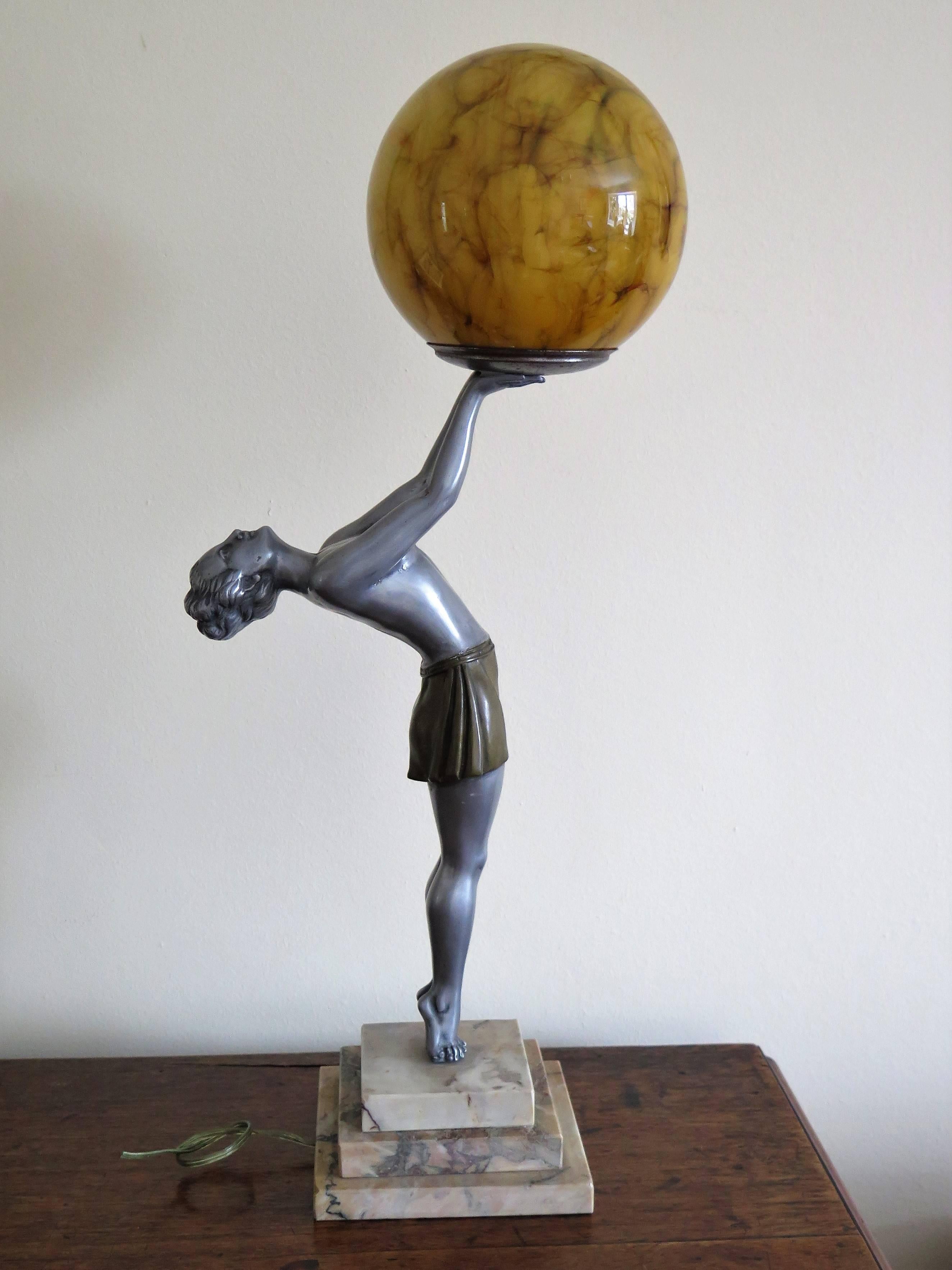 This is a stunning figurine table lamp of the Biba lamp girl after Max Le-Verrier (1891-1973), who was a famous French sculptor, based in Paris.

The figurine is made of a silvered bronze metal, with a gold colored, cold-painted skirt. 

The piece