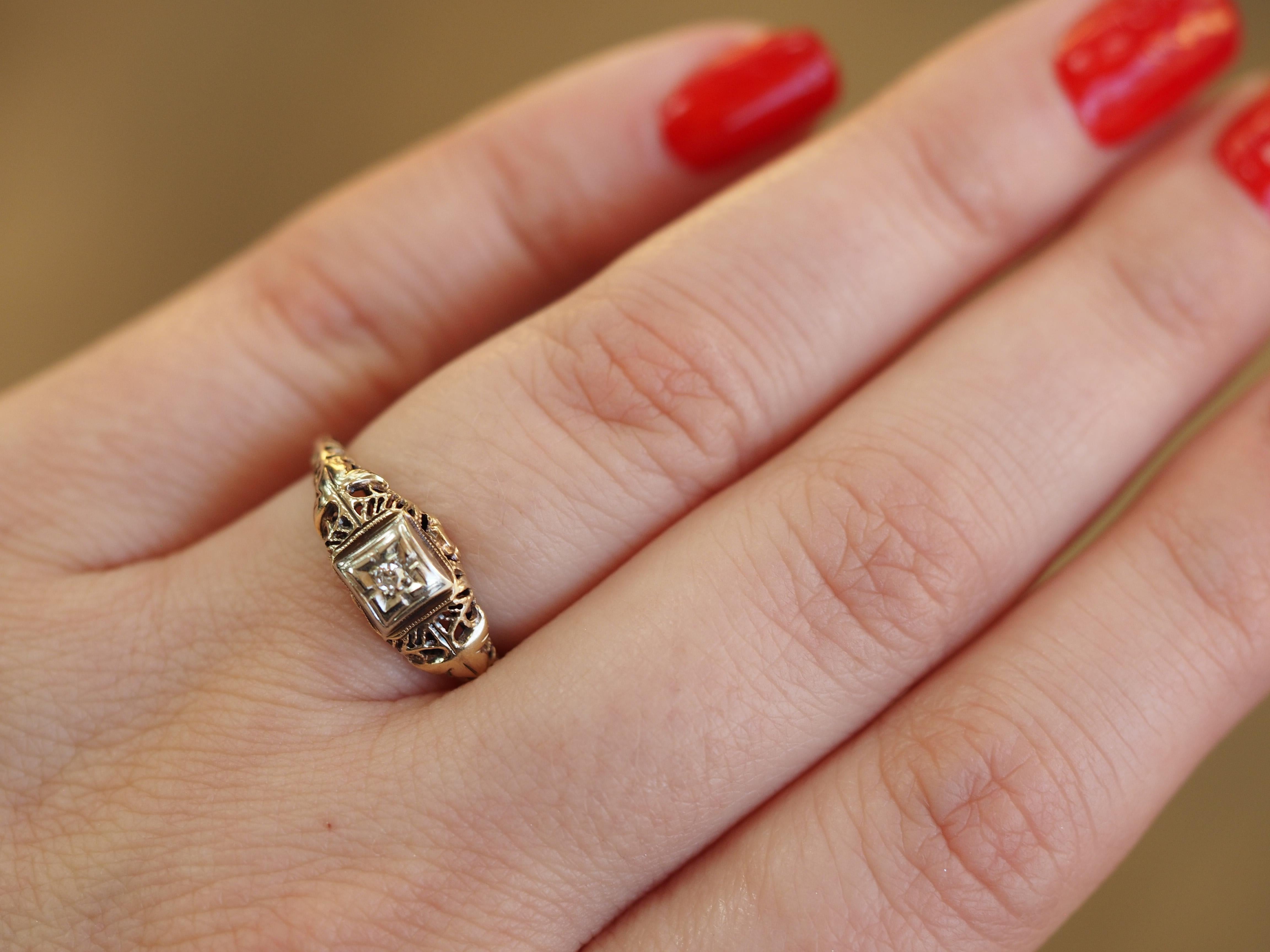 This Art Deco solitaire is a fine example of a filigree solitaire engagement ring crafted in 10 karat white & yellow gold. The 0.03 ct Single cut diamond is held high in four prongs showcasing the solitaire from all sides! The filigree design twists