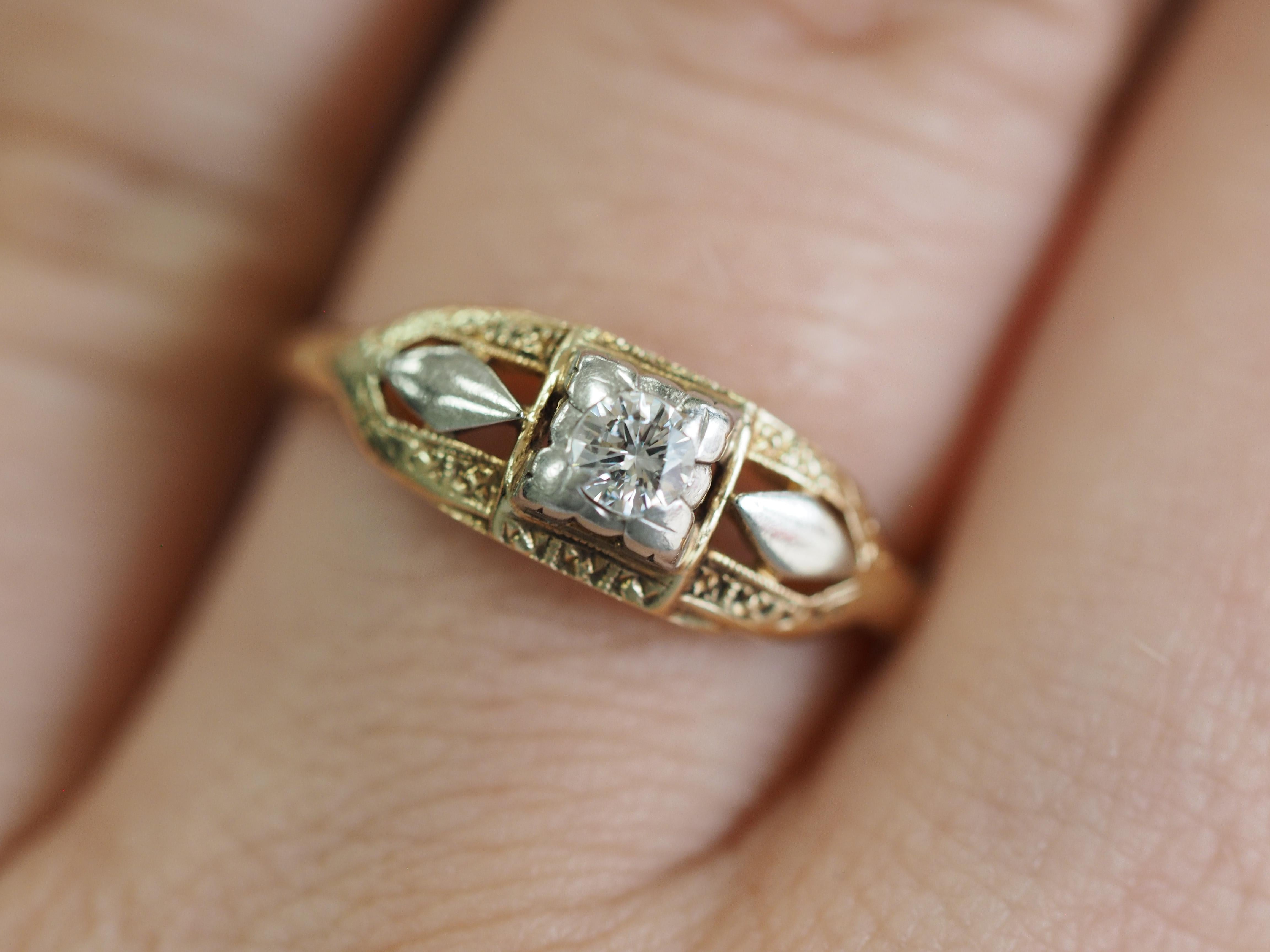 This Art Deco solitaire is a fine example of a filigree solitaire engagement ring crafted in 14 karat white & yellow gold. The 0.11 ct Single cut diamond is held high in four prongs showcasing the solitaire from all sides! The filigree design twists