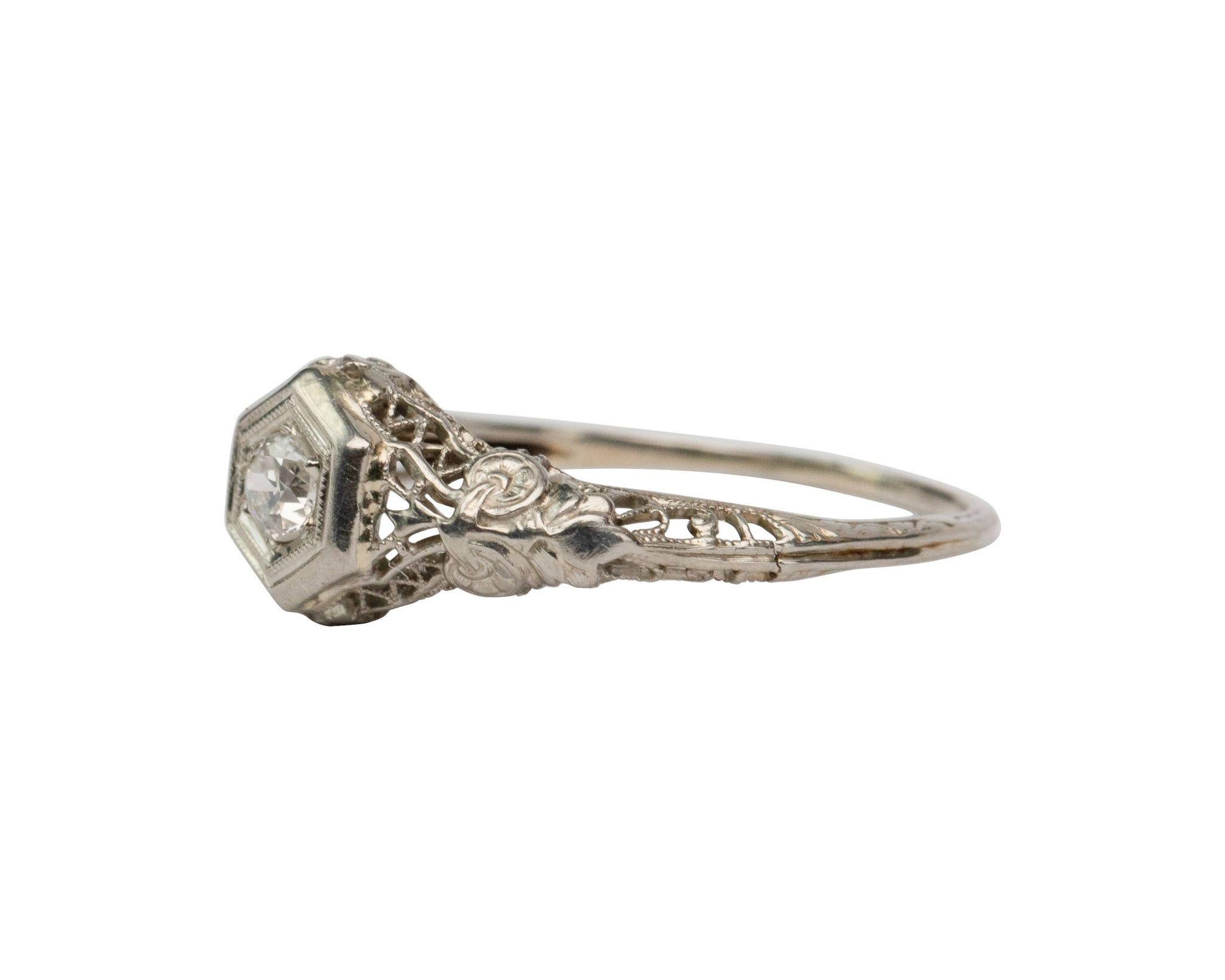 Here we have an lovely example of a 1920's Art Deco solitaire ring. Featuring an old European cut diamond weighing in at .22 carats surrounded with stunning filigree work down the shoulders of the mounting. Simple elegance that is sure to