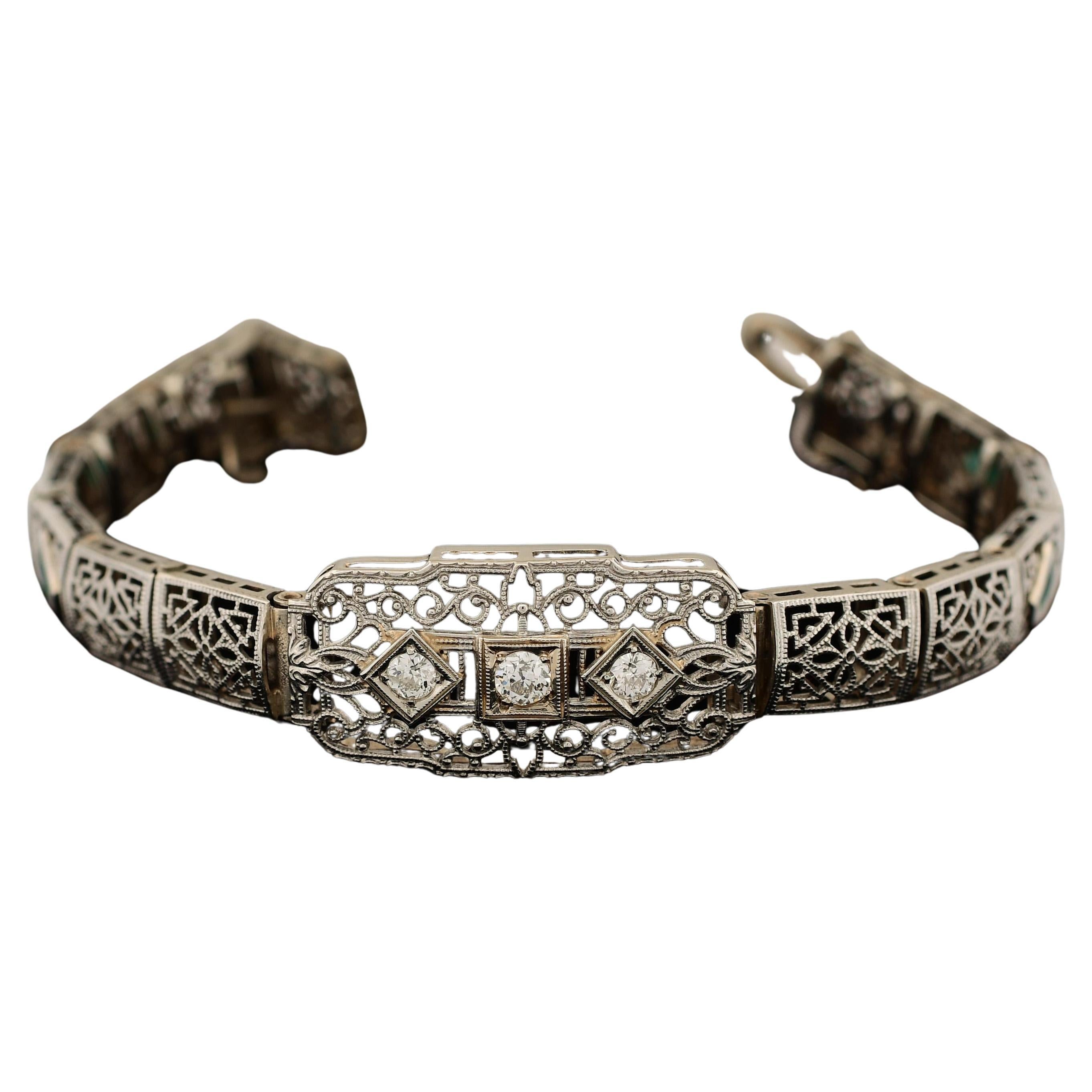 Das filigrane Diamantarmband aus 14 Karat Weißgold mit synthetischen Smaragden im französischen Schliff ist ein bemerkenswertes Schmuckstück, das eine Hommage an die ikonische Ära des Art Déco darstellt. Das exquisite, filigrane Design aus Weißgold