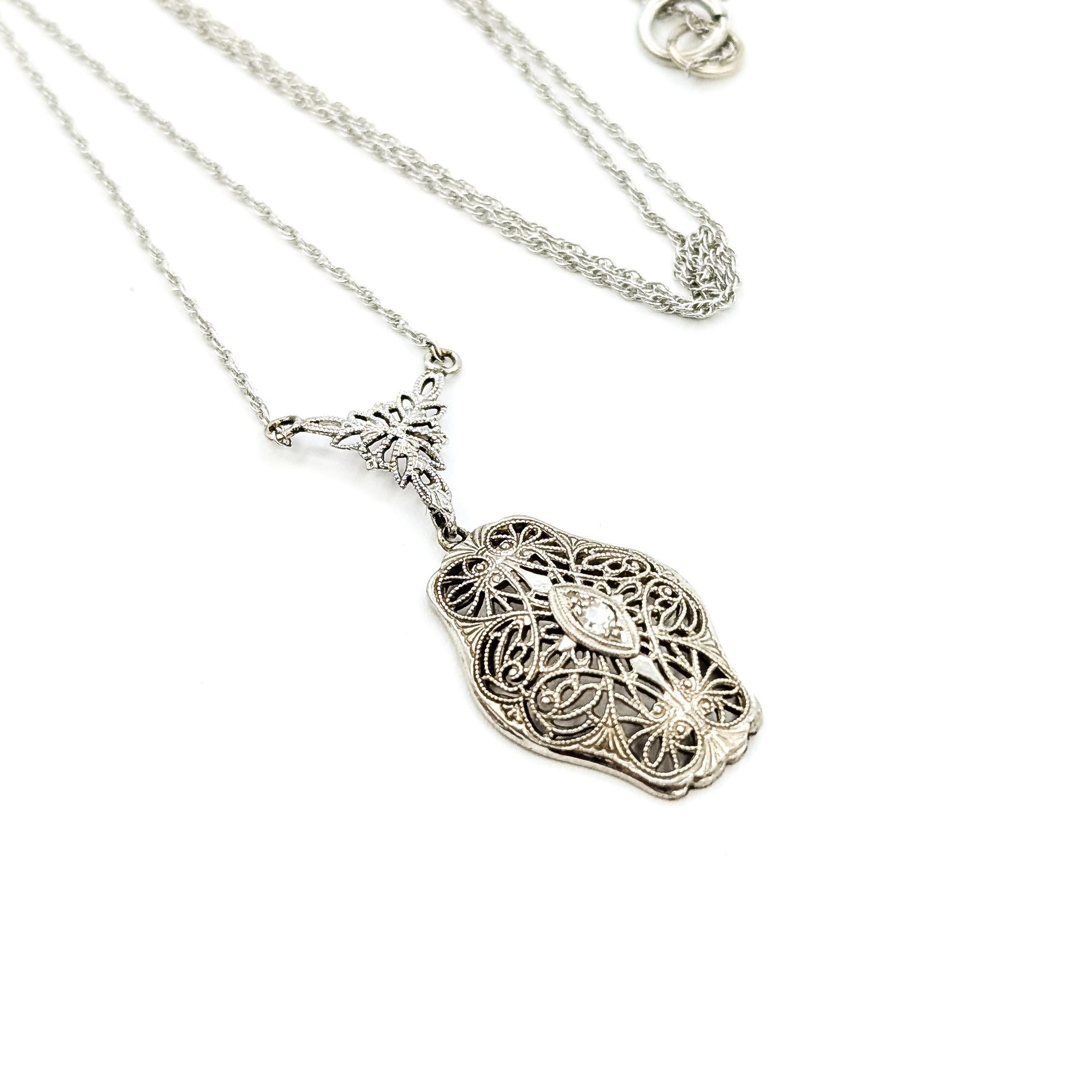 Art Deco Filigrane Diamant-Halskette in 14k

Diese Halskette ist aus 14 Karat Weißgold gefertigt und zeigt einen in Zacken gefassten Diamanten in einem filigranen Anhänger. Das Design ist ein echtes Beispiel für die Ära des Art Déco und spiegelt die