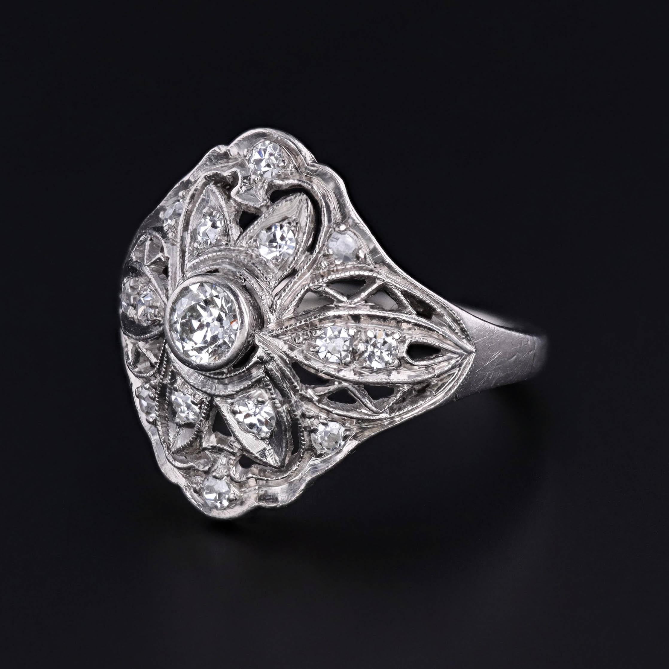 Questo antico anello bomba in filigrana dell'epoca Art Deco presenta una serie di diamanti scintillanti. Il diamante centrale è una pietra antica di taglio europeo da 0,20 carati di colore G-I e purezza SI1 e ci sono 14 diamanti d'accento a taglio