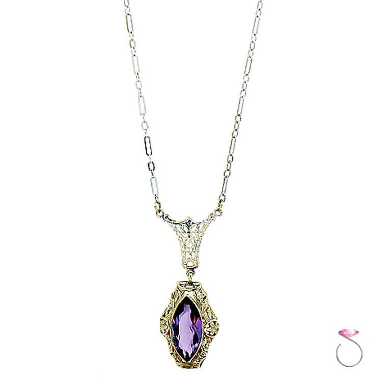 Art Deco Filigree Necklace With Marquise Cut Purple Amethyst in 14K White Gold. The amethyst is bezel set surrounded by a filigree design. The necklace is 16 inches long and the Amethyst pendant drops an additional 1.50 inches. The fancy link chain