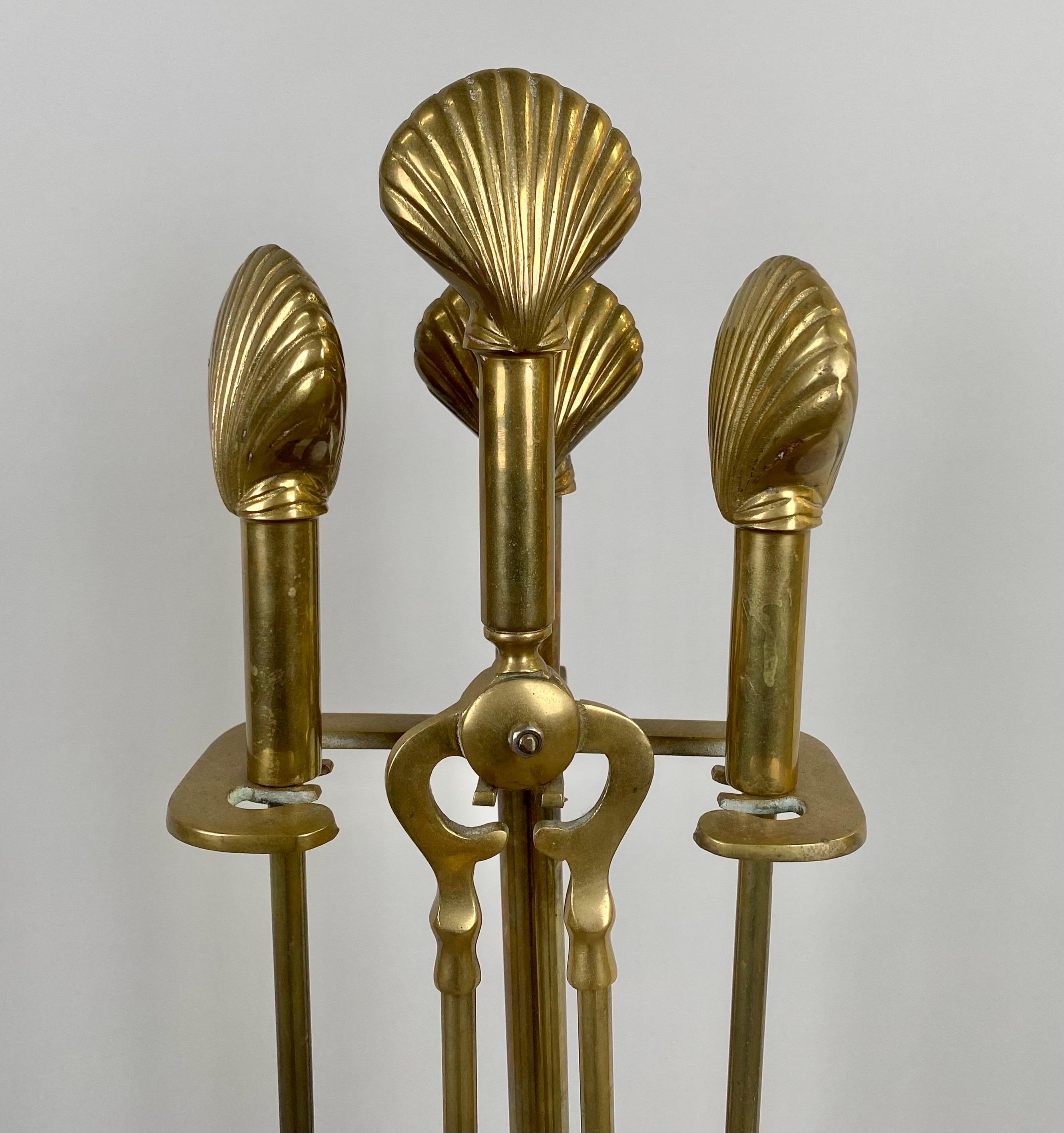 A set of Art Deco fireplace tools, comprising five exquisite pieces, each tool is forged from solid brass, showcasing both durability and opulence. Adorned with a graceful seashell design, these tools transcend functionality to become exquisite