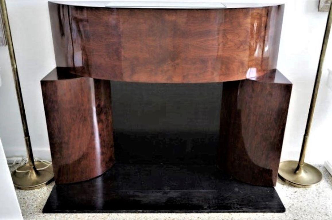 This sylish, streamlined American Art Deco fireplace mantle definetly makes a statement with its form and finish.

As we are showing (lead image) the mantle can be used with a real firebox, or it can be used as a faux fireplace mantle as all of the