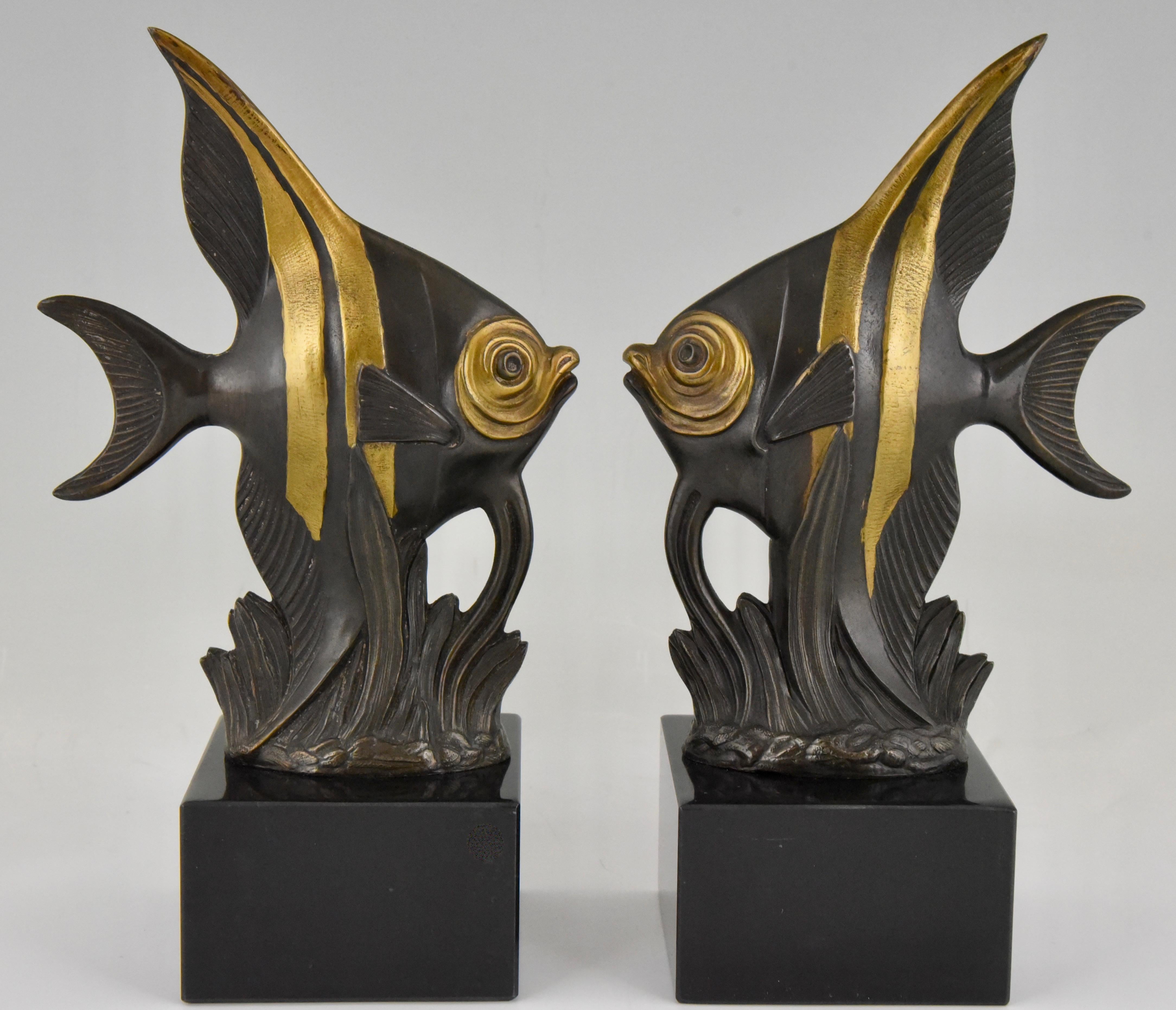 Lovely pair of Art Deco bookends with angelfish by the French artist Luc, 1930. Art metal with brown patina and gilt accents on black marble base.