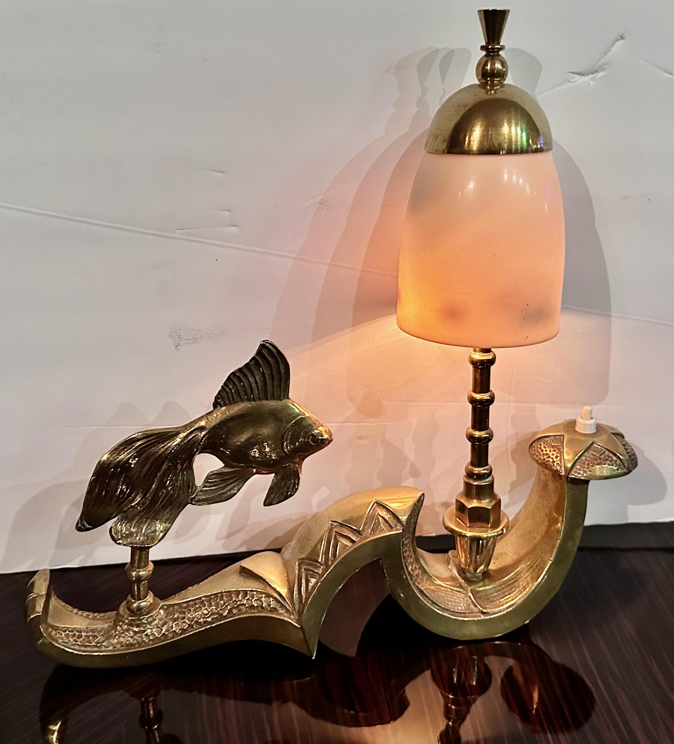 Die Art Deco Fish Sculpture Tischleuchte aus Frankreich ist ein einzigartiges Stück aus Messing mit integrierter Akzentbeleuchtung und einem verschnörkelten Sockel-Design. Die komplizierte Textur und die akribische Liebe zum Detail lassen darauf