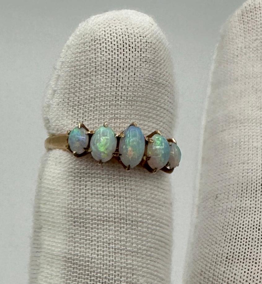 Se trata de un Antiguo Anillo Victoriano - Art Decó con cinco magníficos Ópalos naturales de impresionante belleza. Los ópalos son gemas ovaladas en cabujón y tienen fuego amarillo, verde, naranja, rojo y azul.  Las joyas están engastadas