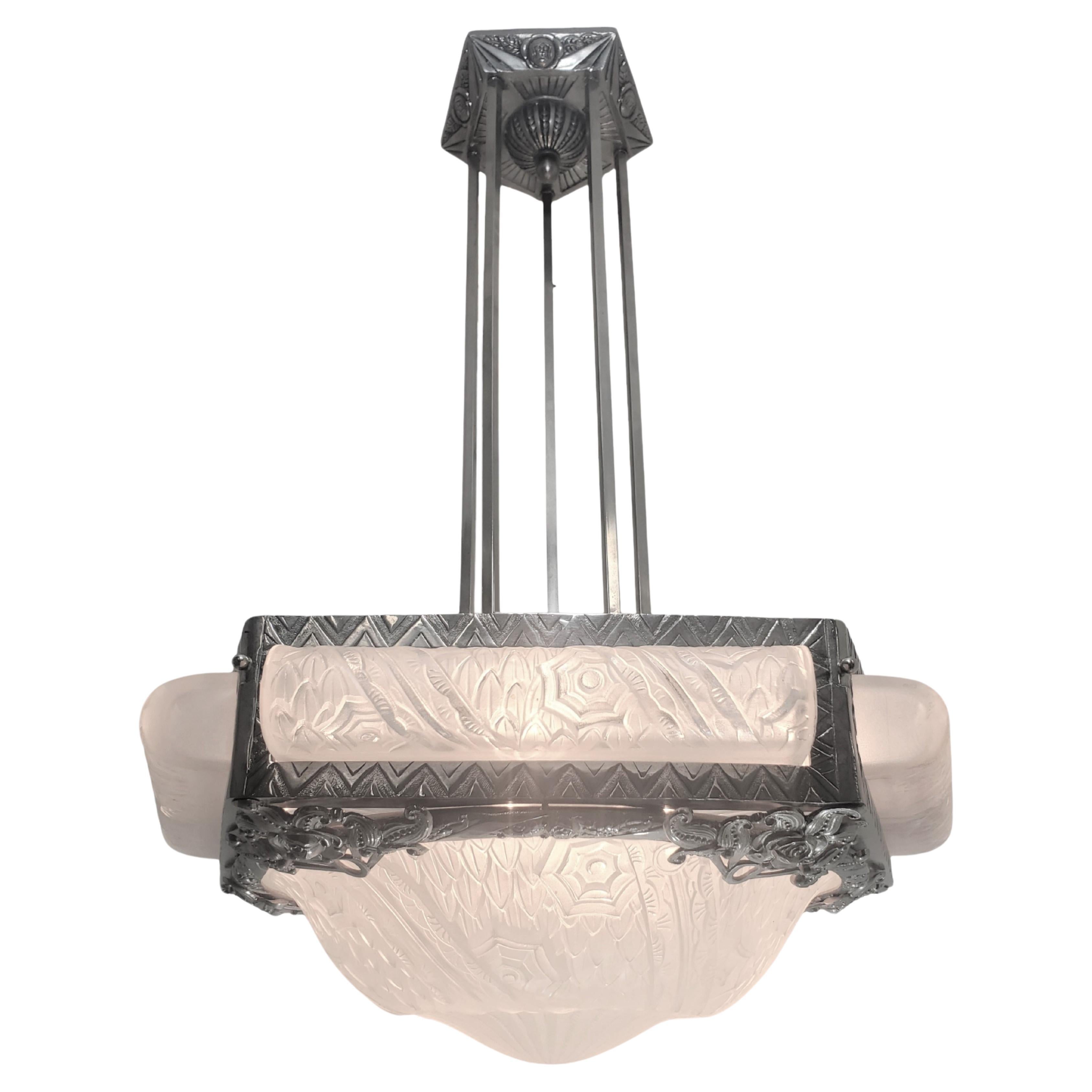 French Modern unusually shaped polished nickel hand hammered iron, pentagonal chandelier showcasing five elongated, tubular, roll shaped frosted art glass insets, each set into a triangular pattered geometric frame surround.  
Signed Schneider,