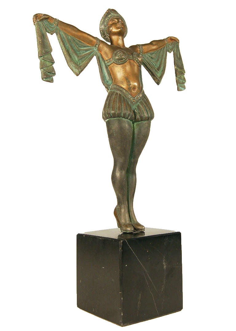 Vintage late 1920s Art Deco statue featuring a flapper dancer caste in Spelter with hand painted green and bronze accents fixed to a black marble base. Stamped 