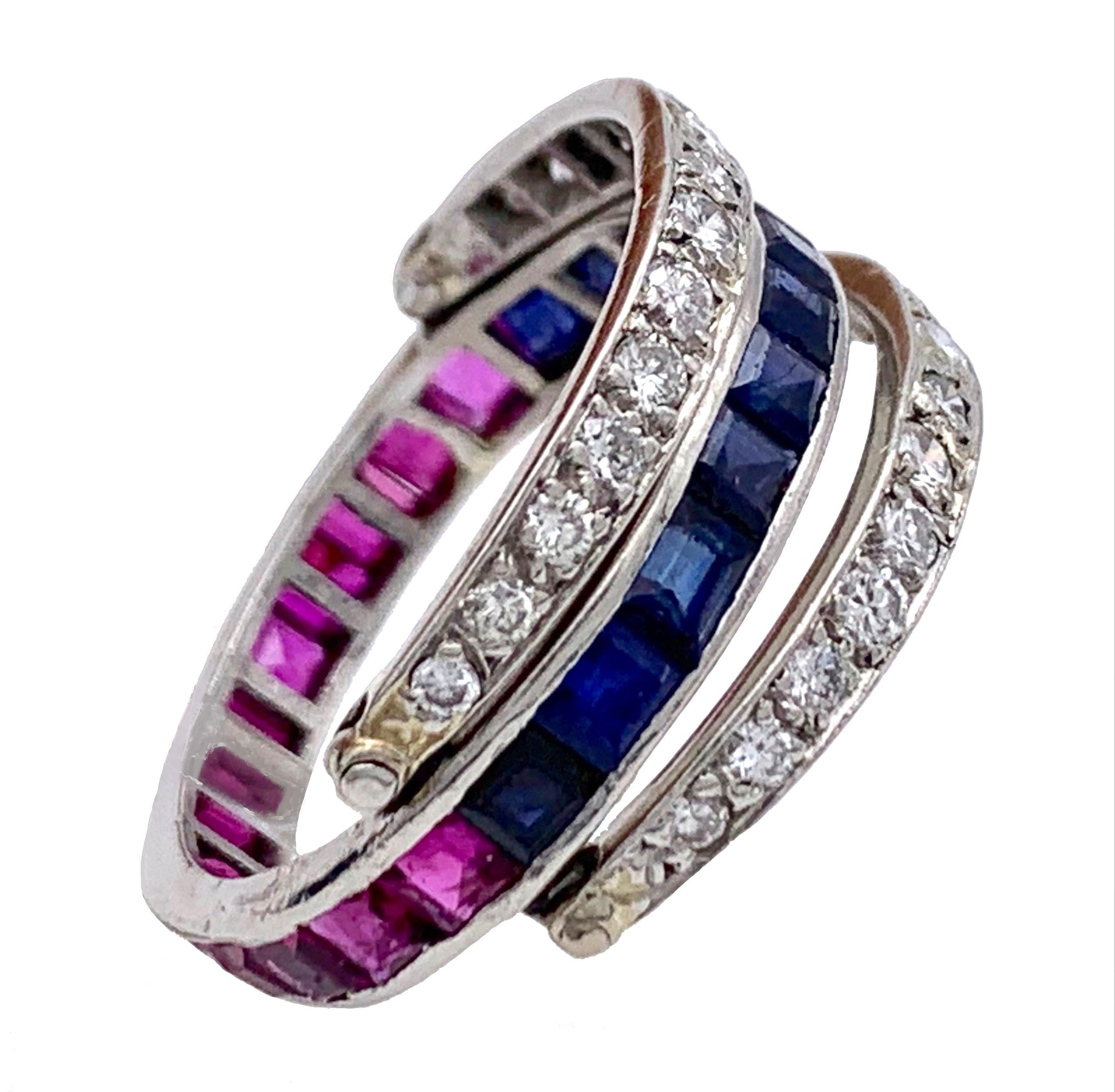 This much loved and wearable early Art Deco flip over eternity Ring has been crafted out of platinum around 1920. It is set with calibré cut rubies and sapphires and with round cut diamonds.
 Us size 7.75